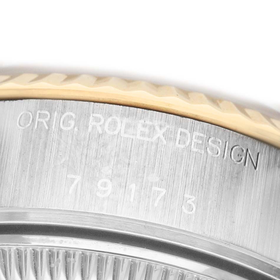 The image shows a close-up of the side with engravings on a Rolex Datejust 79173 Women's Stainless Steel Champagne Dial watch bezel and case.