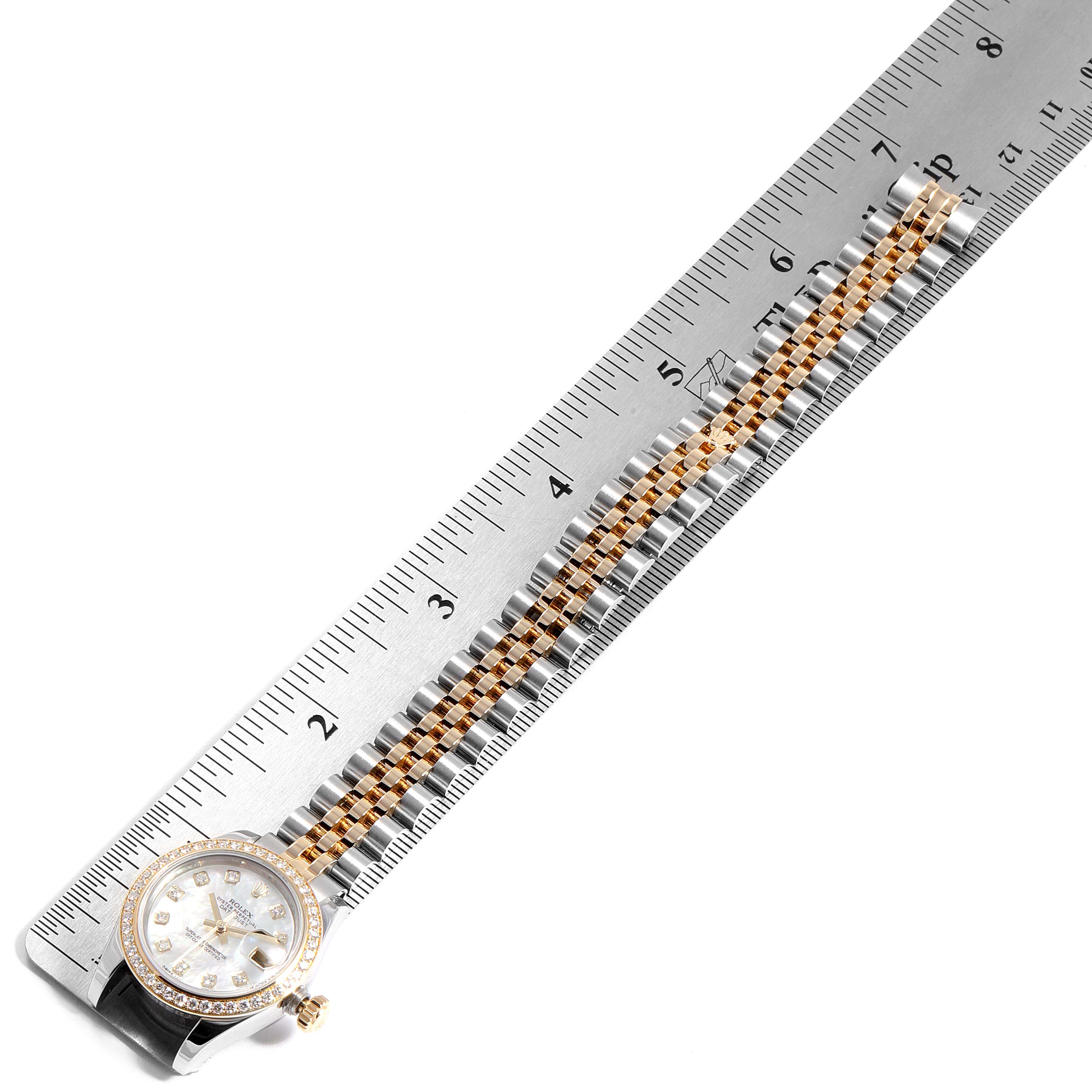 The Rolex Datejust 179383 Women
s Steel and Gold (two tone) Mother of Pearl Dial 179383 Women
s Steel and Gold (two tone) Mother of Pearl Dial watch is shown from the top, displaying its dial, bezel, and the bracelet next to a ruler.