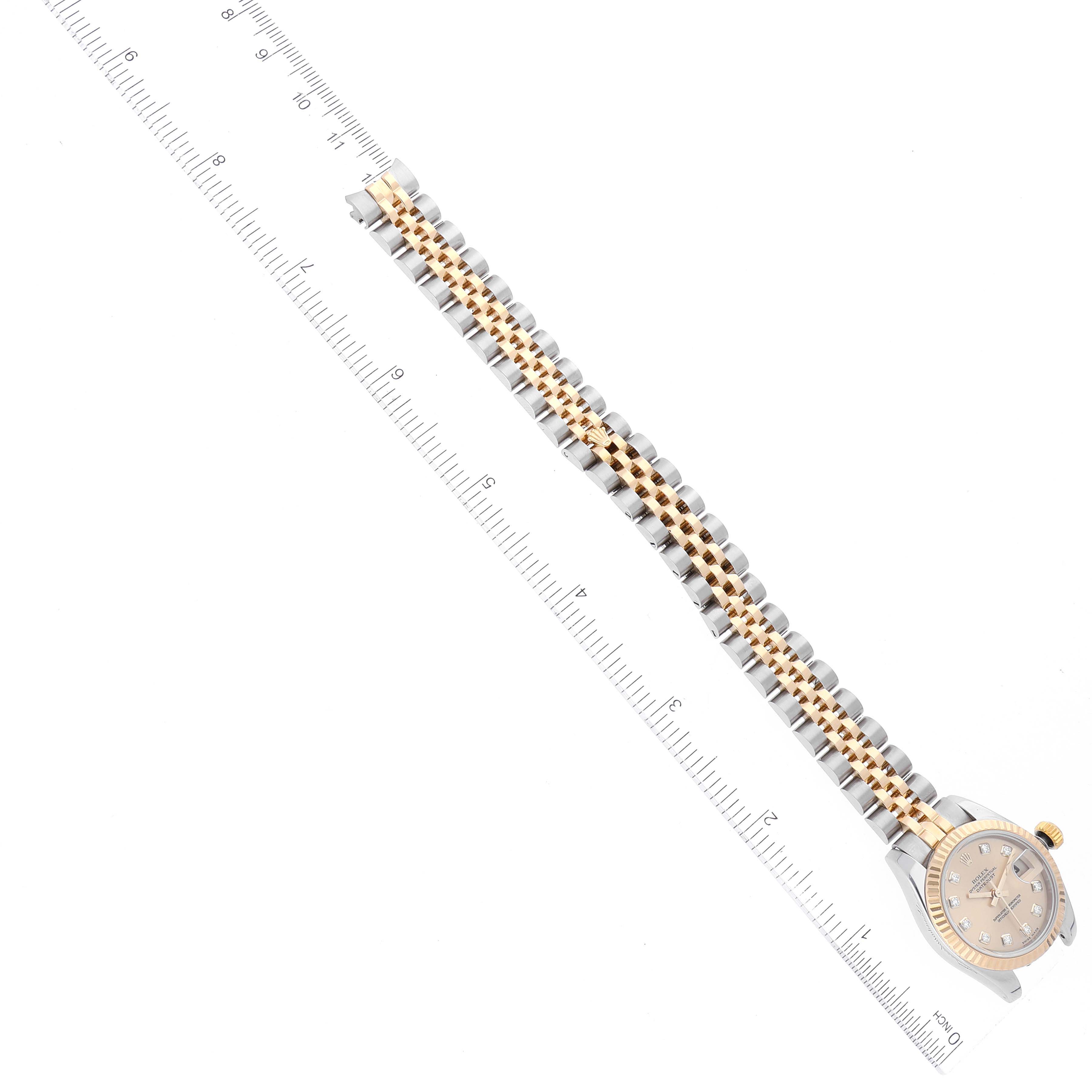 The image shows the Rolex Datejust 179173 Women's Steel and Gold (two tone) Champagne Dial 179173 Women's Steel and Gold (two tone) Champagne Dial watch lying flat with its band extended, placed next to a ruler for measurement.