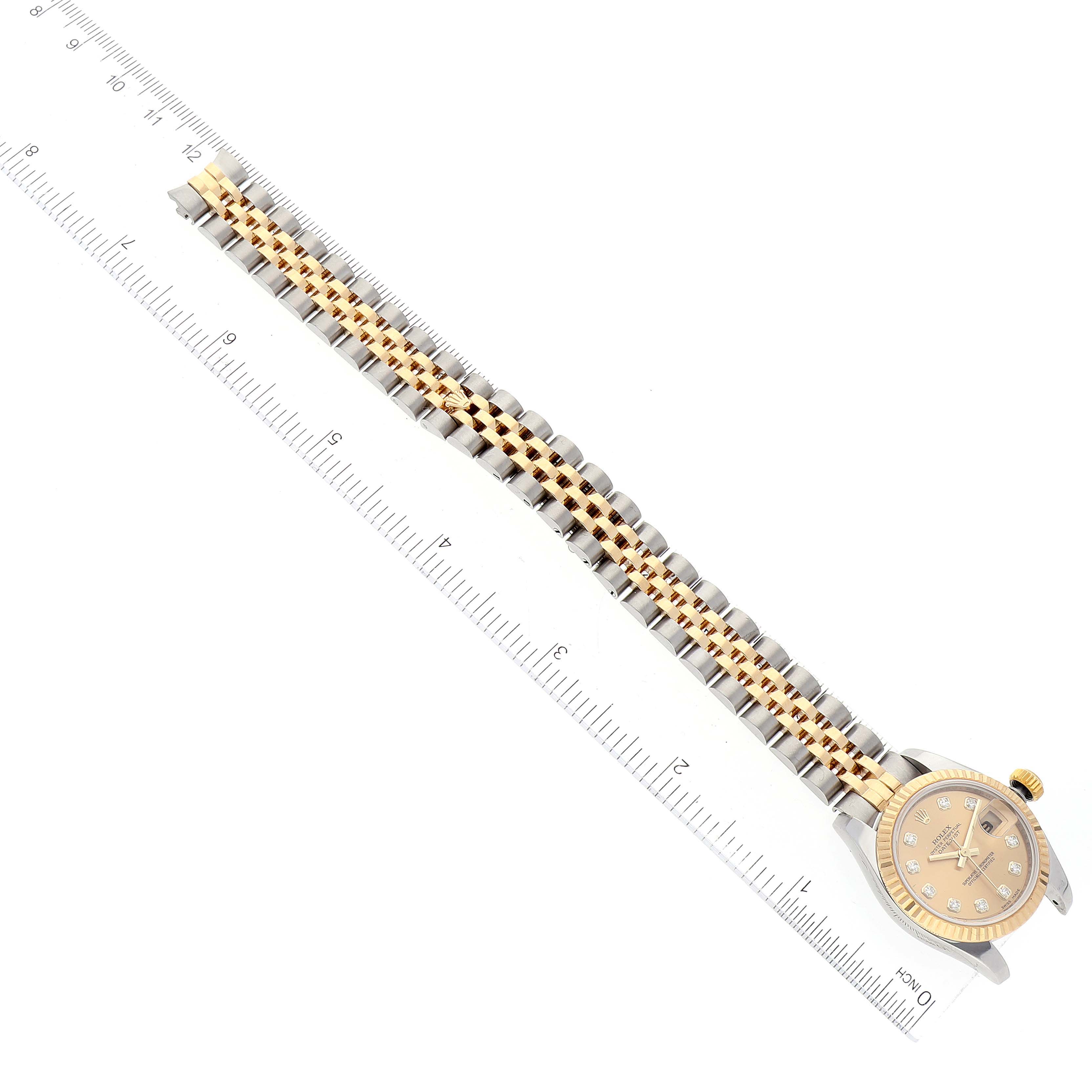 The Rolex Datejust 179173 Women's Steel and Gold (two tone) Champagne Dial 179173 Women's Steel and Gold (two tone) Champagne Dial watch is shown from an overhead angle, displaying its full length, two-tone bracelet, and part of the watch face.
