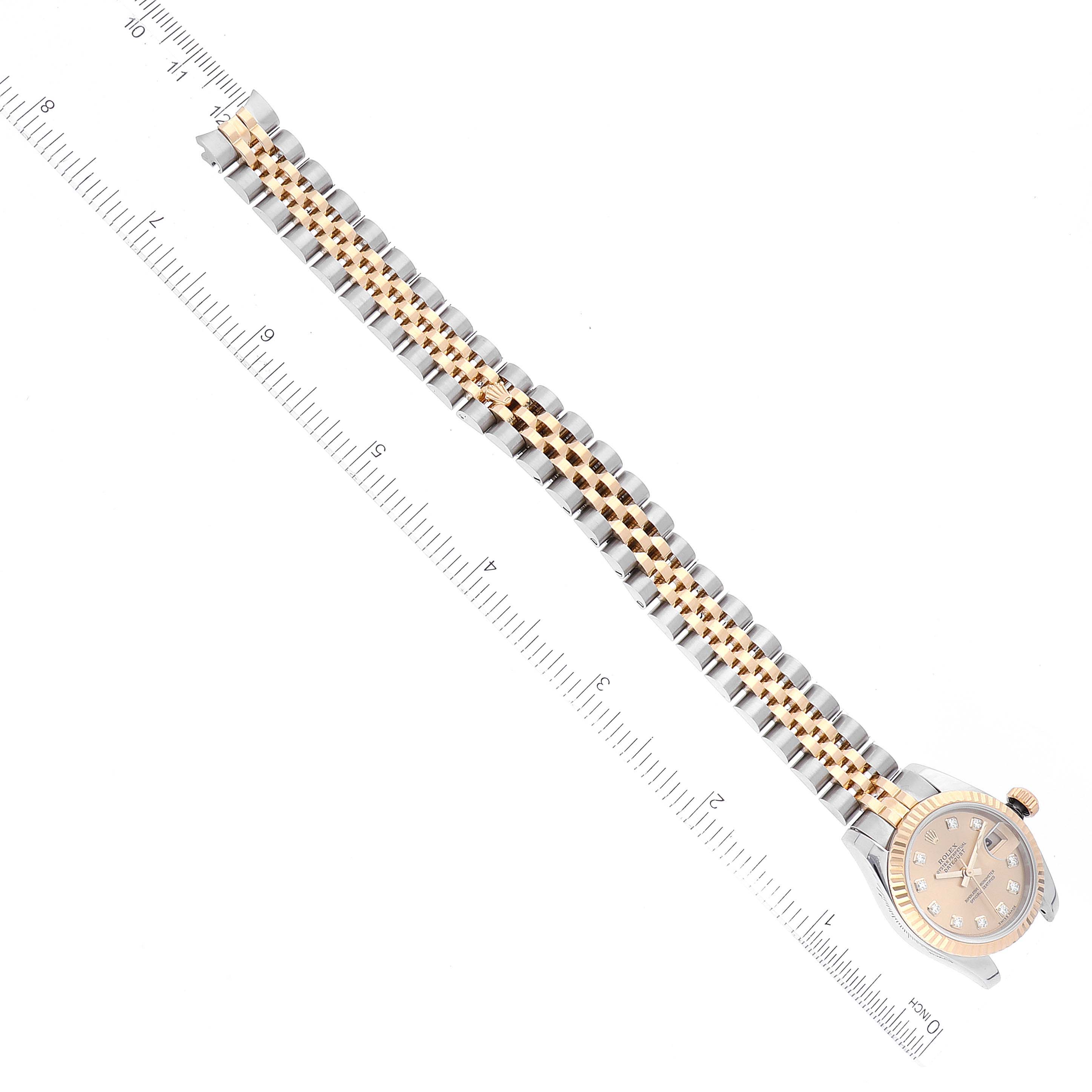 The image shows a Rolex Datejust 179173 Women's Steel and Gold (two tone) Champagne Dial 179173 Women's Steel and Gold (two tone) Champagne Dial watch from a top-down angle, displaying the entire band and watch face with a ruler beside it.