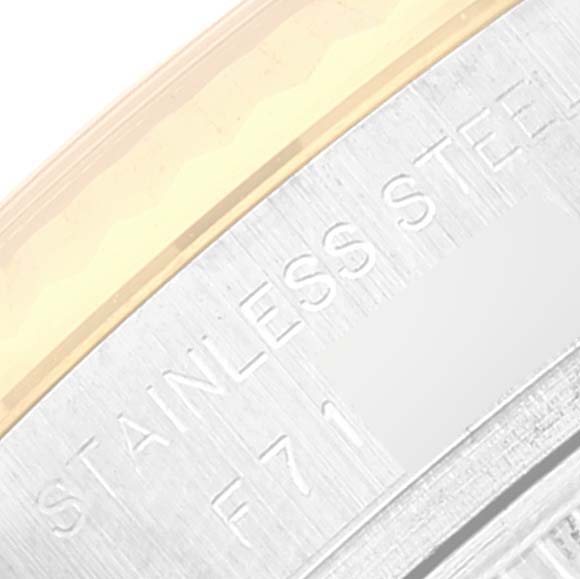 This close-up image shows the engraved text on the case side of a Rolex Datejust 179173 Women's Steel and Gold (two tone) Champagne Dial 179173 Women's Steel and Gold (two tone) Champagne Dial watch, revealing material information.