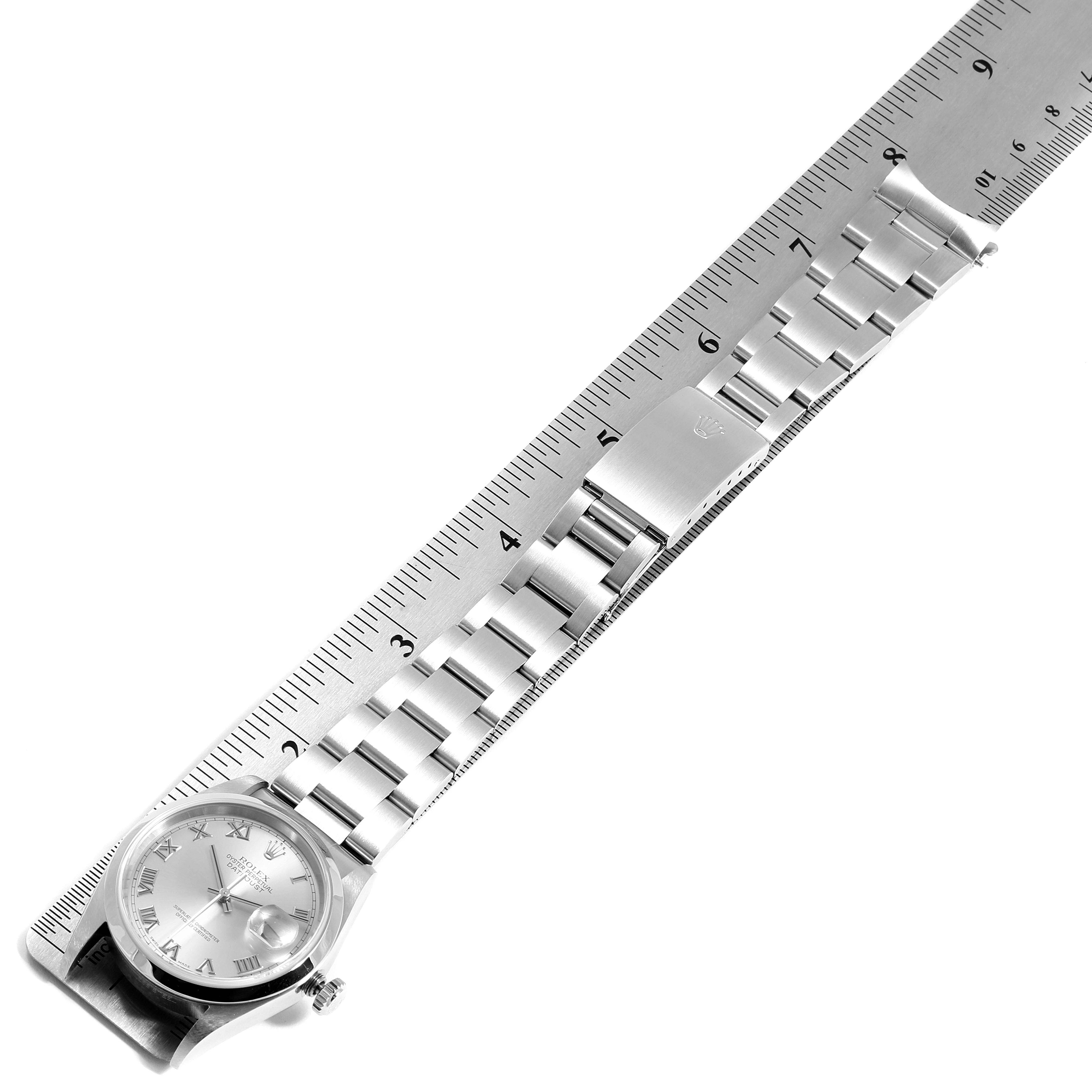 The image shows a top view of a Rolex Datejust 16200 Men
s Stainless Steel Grey Dial 16200 Men
s Stainless Steel Grey Dial watch, demonstrating the watch face, bracelet, and clasp next to a ruler for scale.
