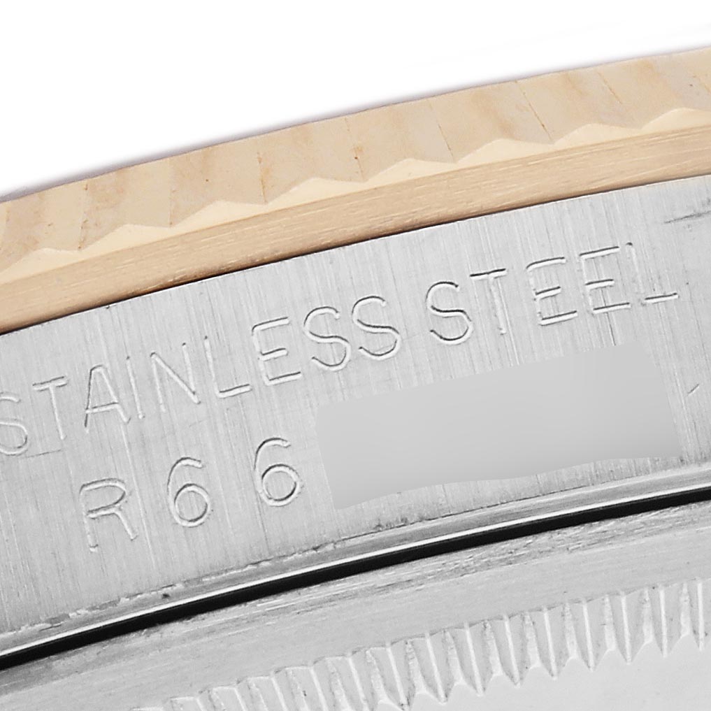 The image shows a close-up side view of the engraved case edge and fluted bezel of a Rolex Datejust 16233 Men
s Steel and Gold (two tone) Champagne Dial 16233 Men
s Steel and Gold (two tone) Champagne Dial watch.