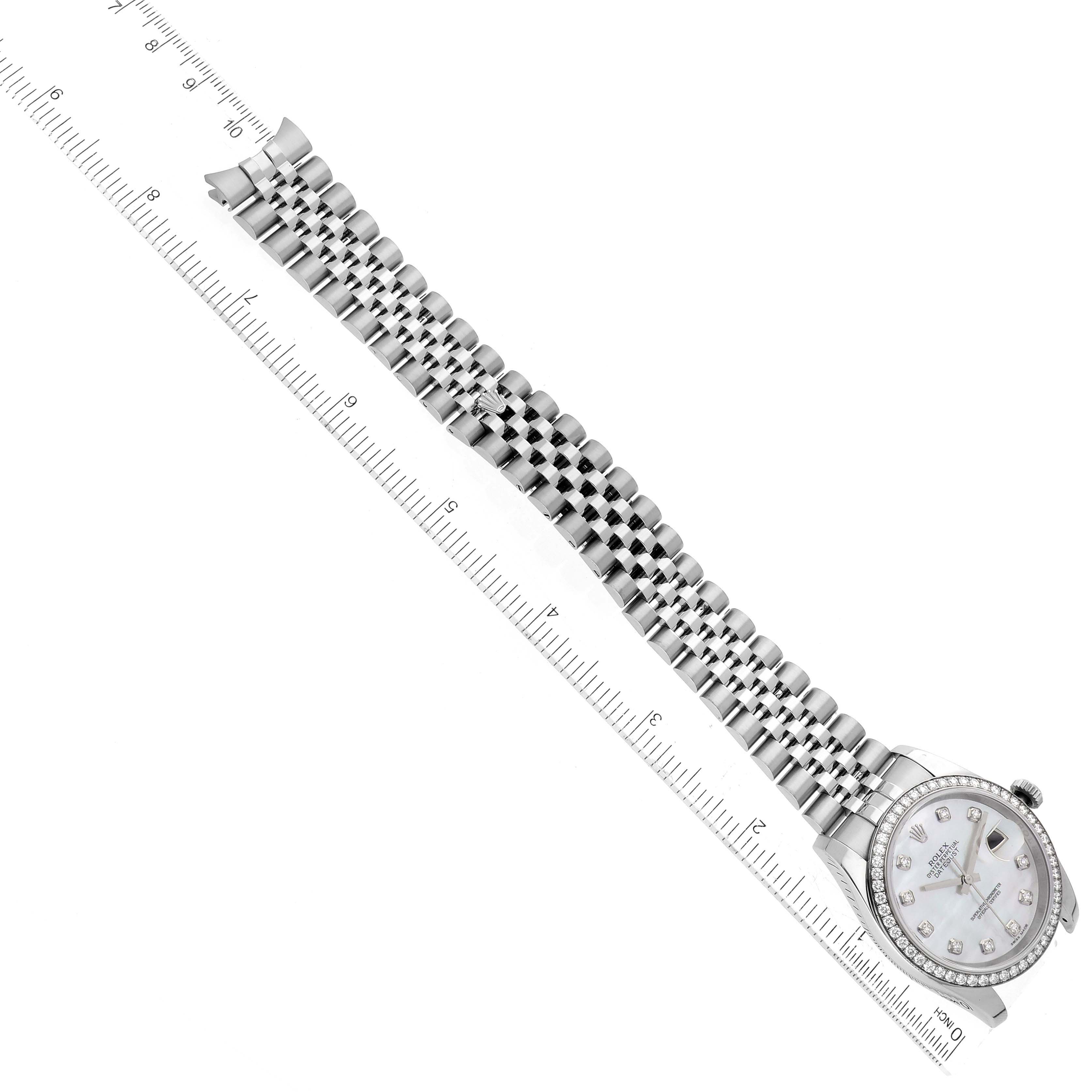 This is a top-down view of a Rolex Datejust 116244 Men's Stainless Steel Mother of Pearl Dial 116244 Men's Stainless Steel Mother of Pearl Dial watch with its bracelet and ruler for scale.