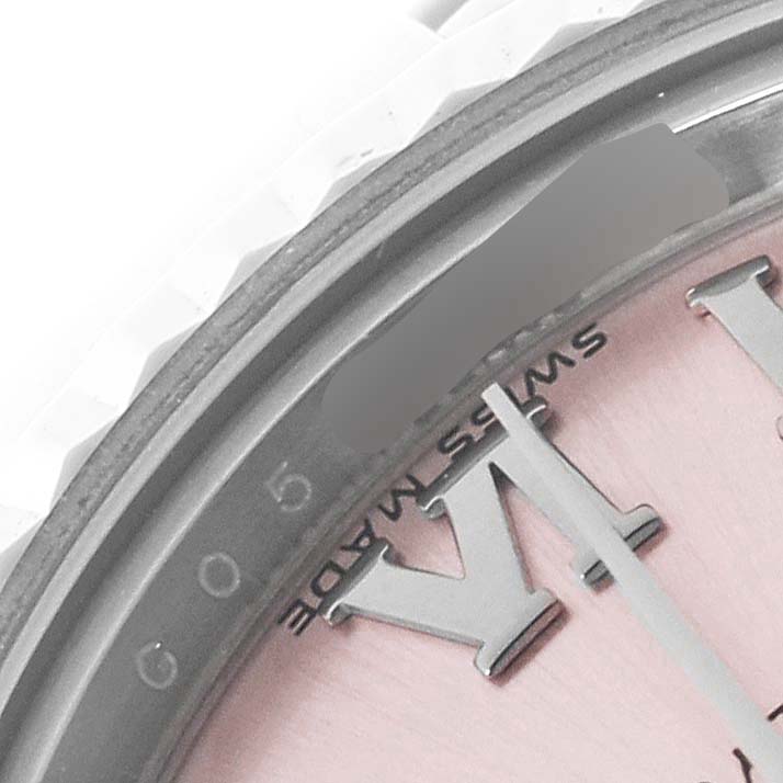 The image shows a close-up of a Rolex Datejust 179174 Women's Stainless Steel Pink Dial, highlighting the dial edge, Roman numerals, and part of the fluted bezel.