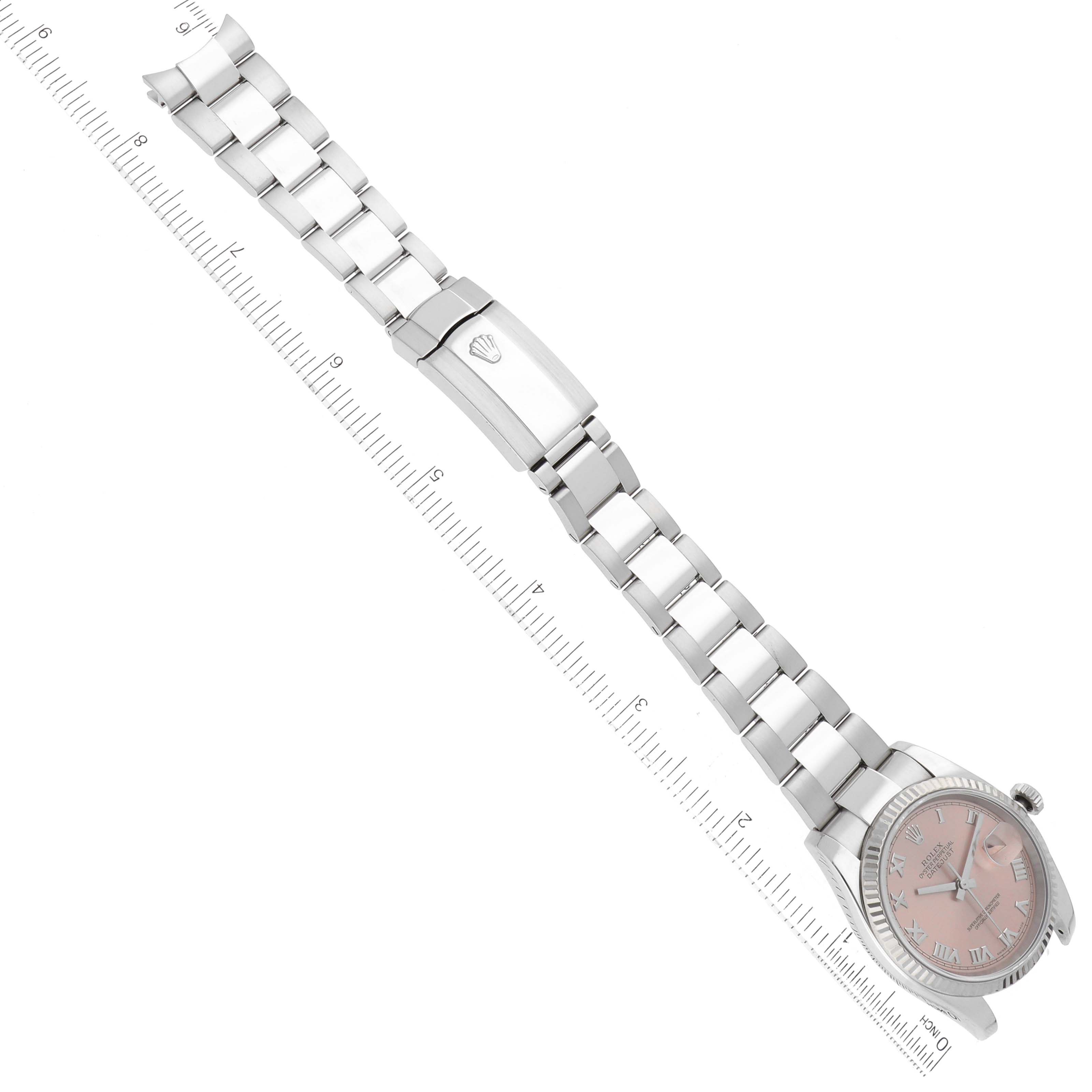 The Rolex Datejust 116234 Men's Stainless Steel Pink Dial 116234 Men's Stainless Steel Pink Dial model watch is shown from a top-down angle, displaying the face and full bracelet with a ruler alongside for scale.