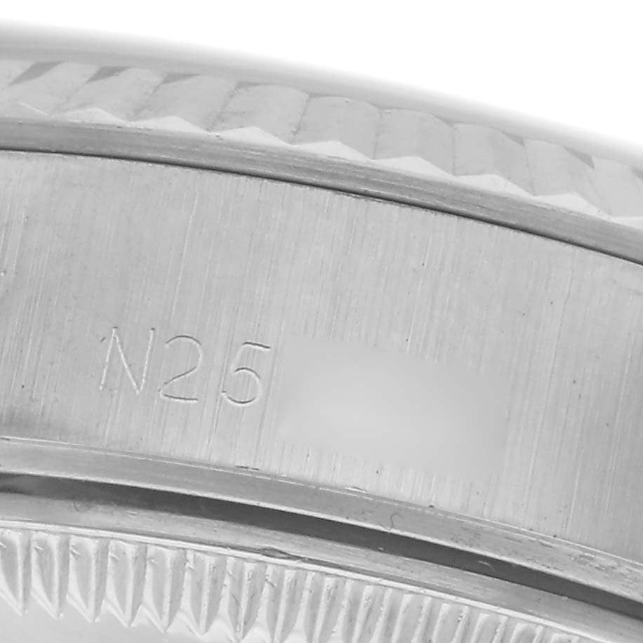 The image shows a close-up of the engraved bezel and edge of the case of a Rolex Datejust 69174 Women
s Stainless Steel Silver Dial 69174 Women
s Stainless Steel Silver Dial watch.