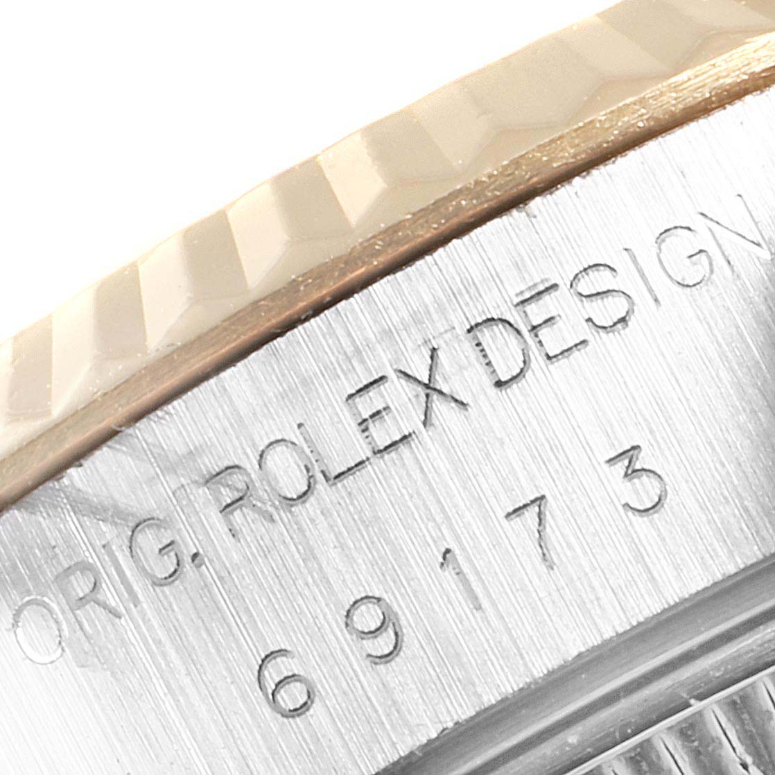 The image shows a close-up of the side inscriptions and the bezel edge on a Rolex Datejust 69173 Women
s Steel and Gold (two tone) Beige Dial 69173 Women
s Steel and Gold (two tone) Beige Dial watch.