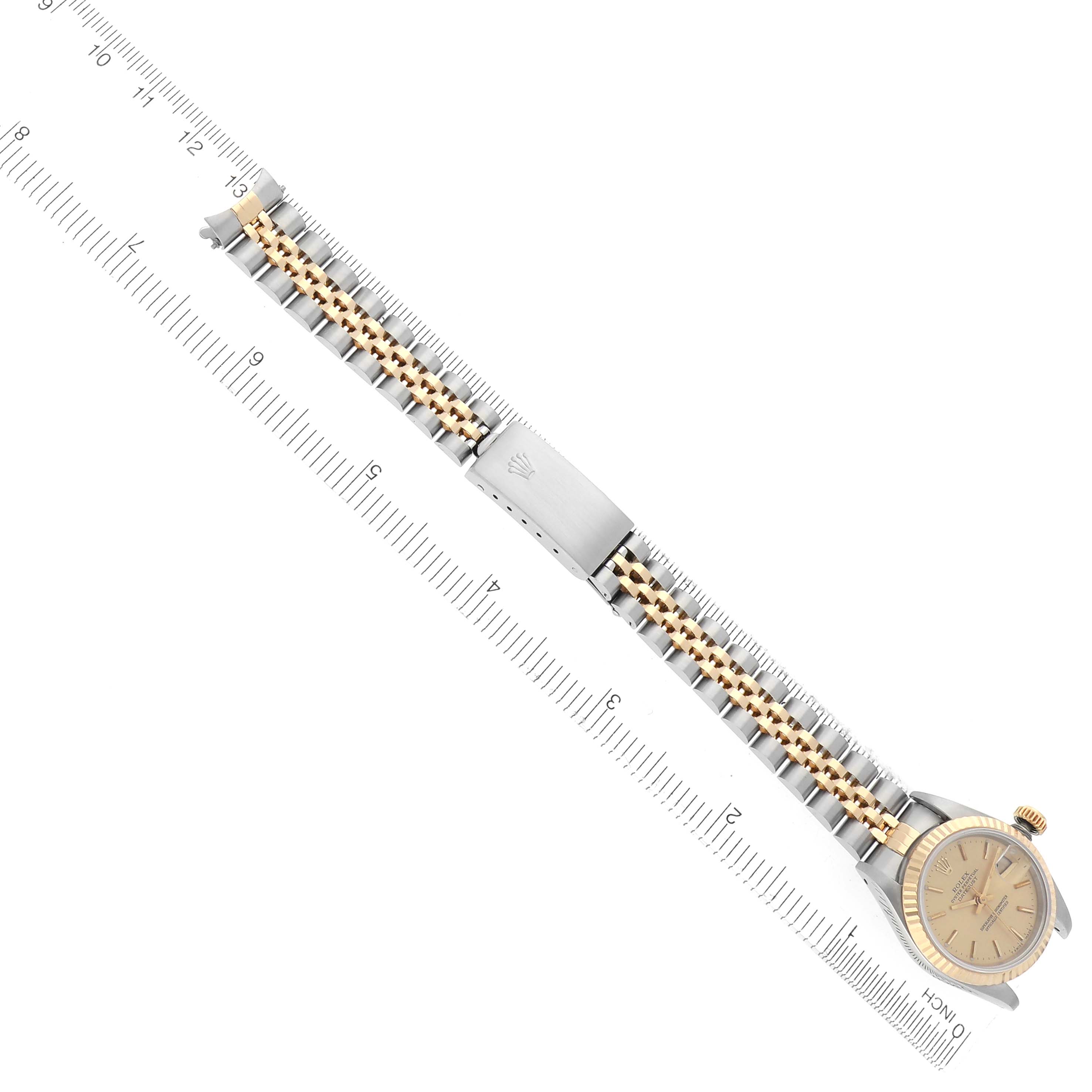 The image shows a Rolex Datejust 69173 Women
s Steel and Gold (two tone) Champagne Dial 69173 Women
s Steel and Gold (two tone) Champagne Dial watch laid flat, displaying the bracelet, clasp, and part of the dial at a diagonal angle.