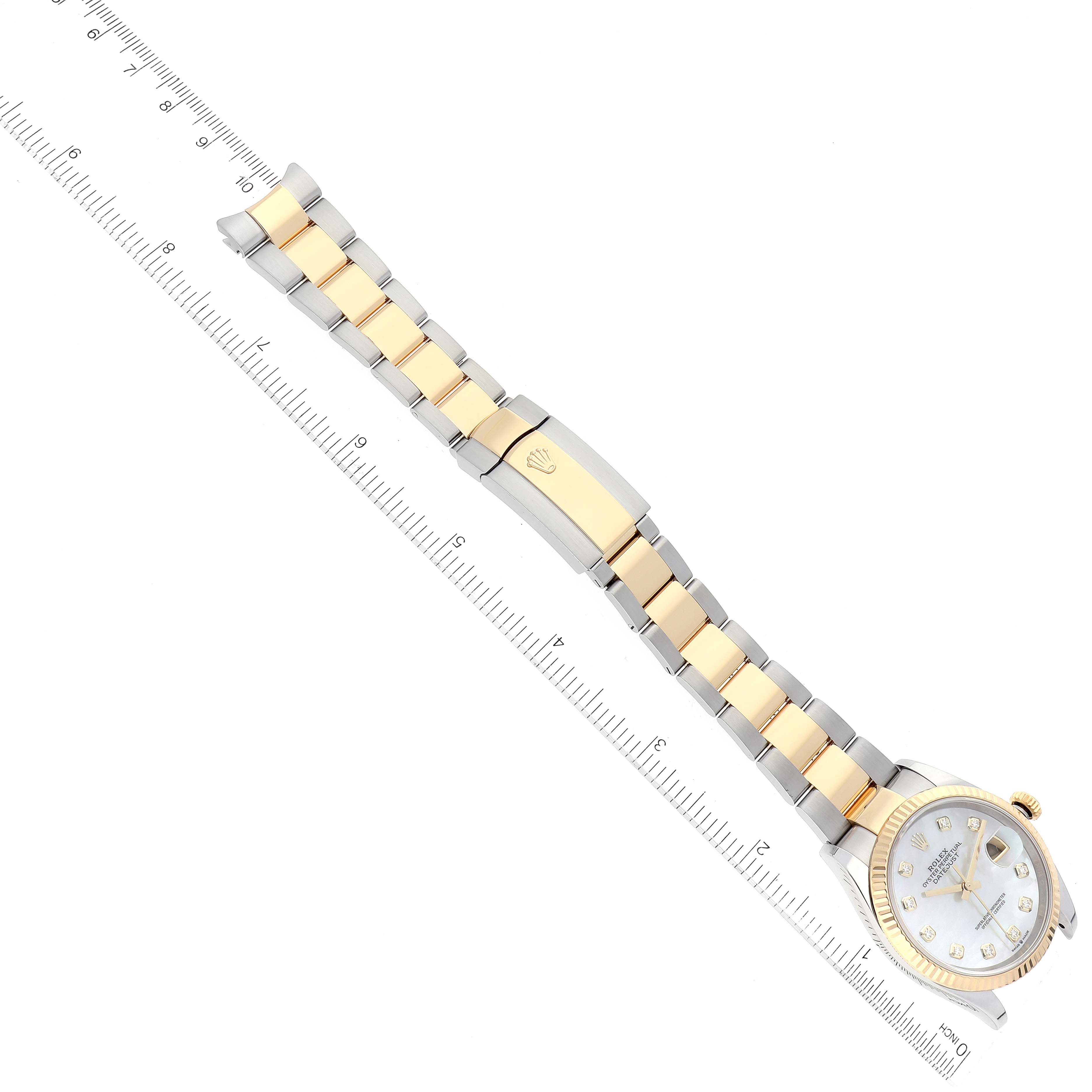 This image shows a Rolex Datejust 126233 Men's Steel and Gold (two tone) Mother of Pearl Dial 126233 Men's Steel and Gold (two tone) Mother of Pearl Dial watch from an angled top view, highlighting the face, bezel, and two-tone bracelet against a ruler.