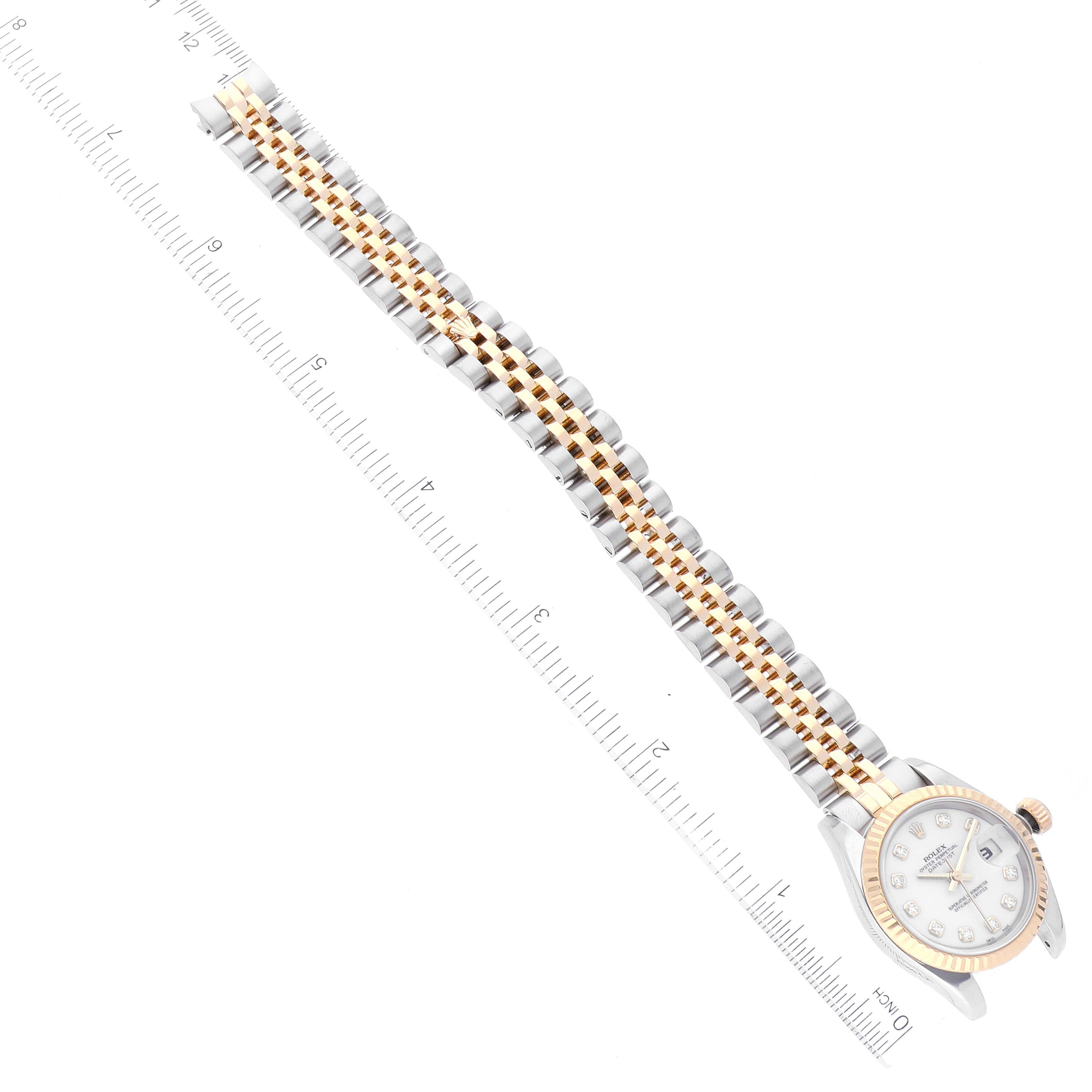 The image shows a top-down view of the Rolex Datejust 179173 Women's Steel and Gold (two tone) White Dial 179173 Women's Steel and Gold (two tone) White Dial watch's face and full bracelet positioned along a measuring ruler.