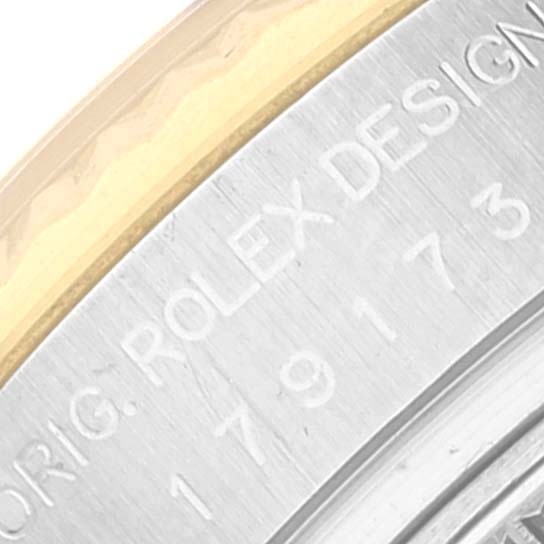 The image shows a close-up of the side of a Rolex Datejust 179173 Women's Steel and Gold (two tone) White Dial 179173 Women's Steel and Gold (two tone) White Dial watch, displaying part of the case with engraved text and bezel.