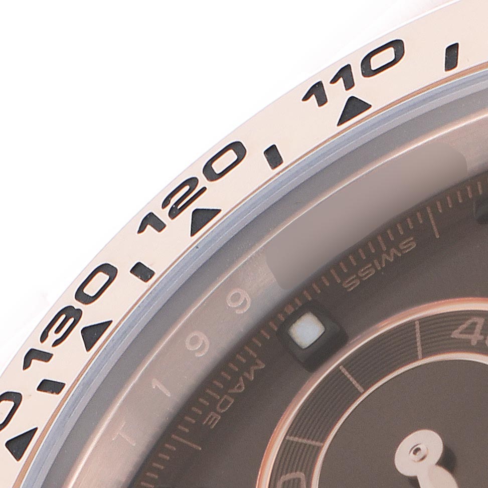 The image shows a close-up of the bezel and part of the dial of a Rolex Daytona 116505 Men
s Rose Gold Brown Dial 116505 Men
s Rose Gold Brown Dial watch, highlighting the tachymetric scale.