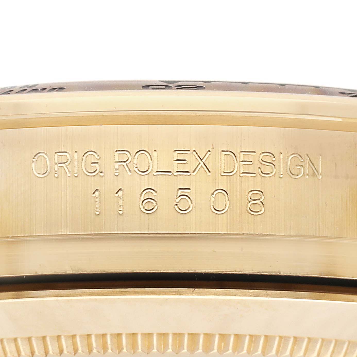 The image shows a close-up of the engraved side of the Rolex Daytona 116508 Men
s Yellow Gold Black Dial 116508 Men
s Yellow Gold Black Dial model, highlighting the "ORIG. ROLEX DESIGN 116508" inscription.