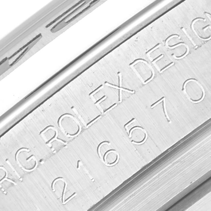 This close-up image shows the engraved serial number and "ROLEX DESIGN" text on the casing of a Rolex Explorer 216570 Men
s Stainless Steel Black Dial 216570 Men
s Stainless Steel Black Dial watch.