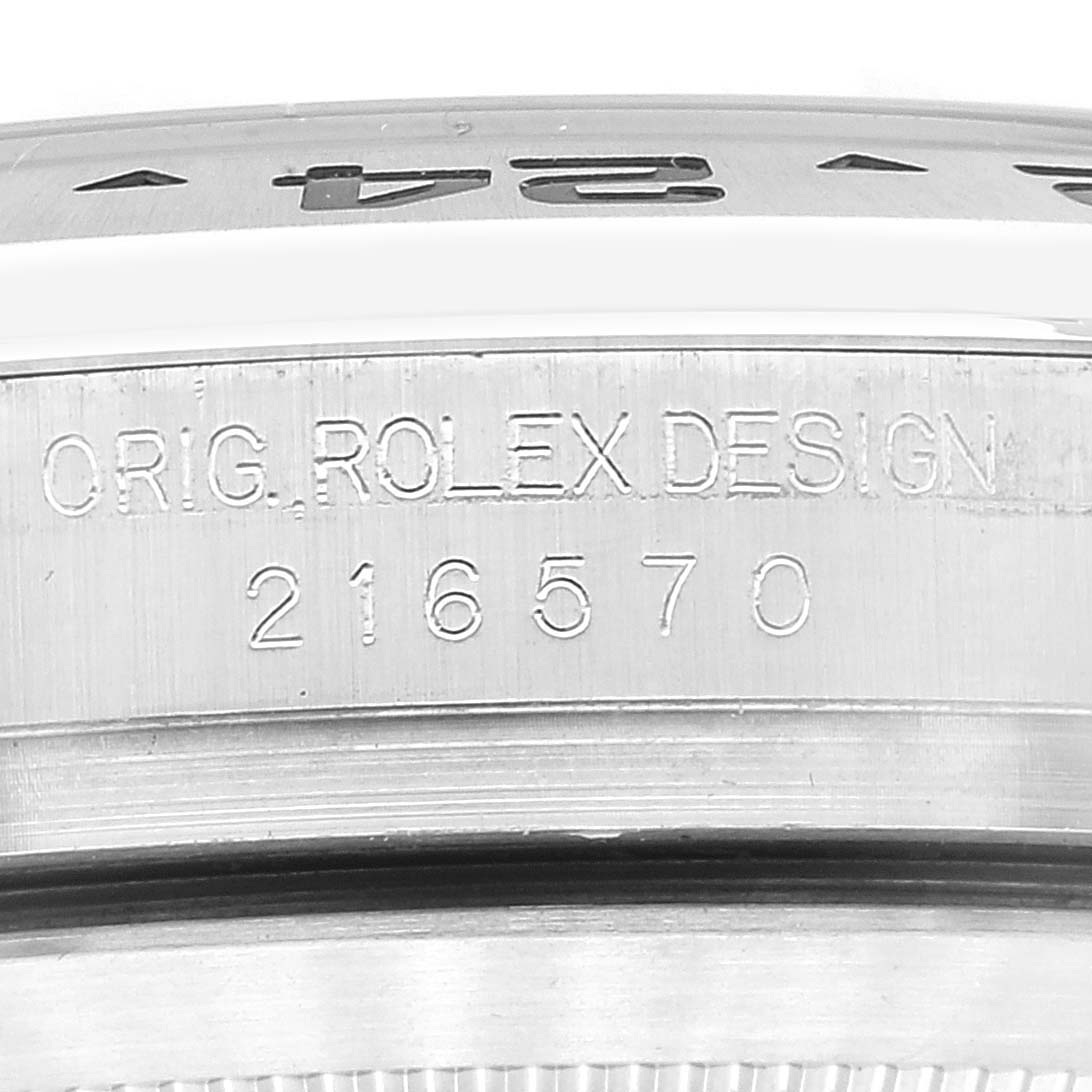 This image shows an angled close-up of the case side of a Rolex Explorer 216570 Men's Stainless Steel Black Dial 216570 Men's Stainless Steel Black Dial, displaying the model number and "ORIG. ROLEX DESIGN" engraving.