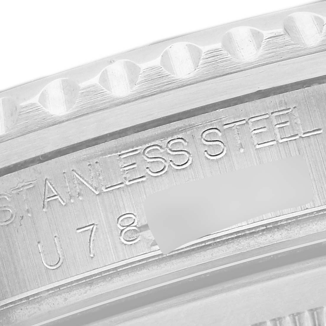 The image shows a close-up of the stainless steel bezel and engraved serial number of a Rolex GMT-Master 16710 Men's Stainless Steel Black Dial 16710 Men's Stainless Steel Black Dial watch.