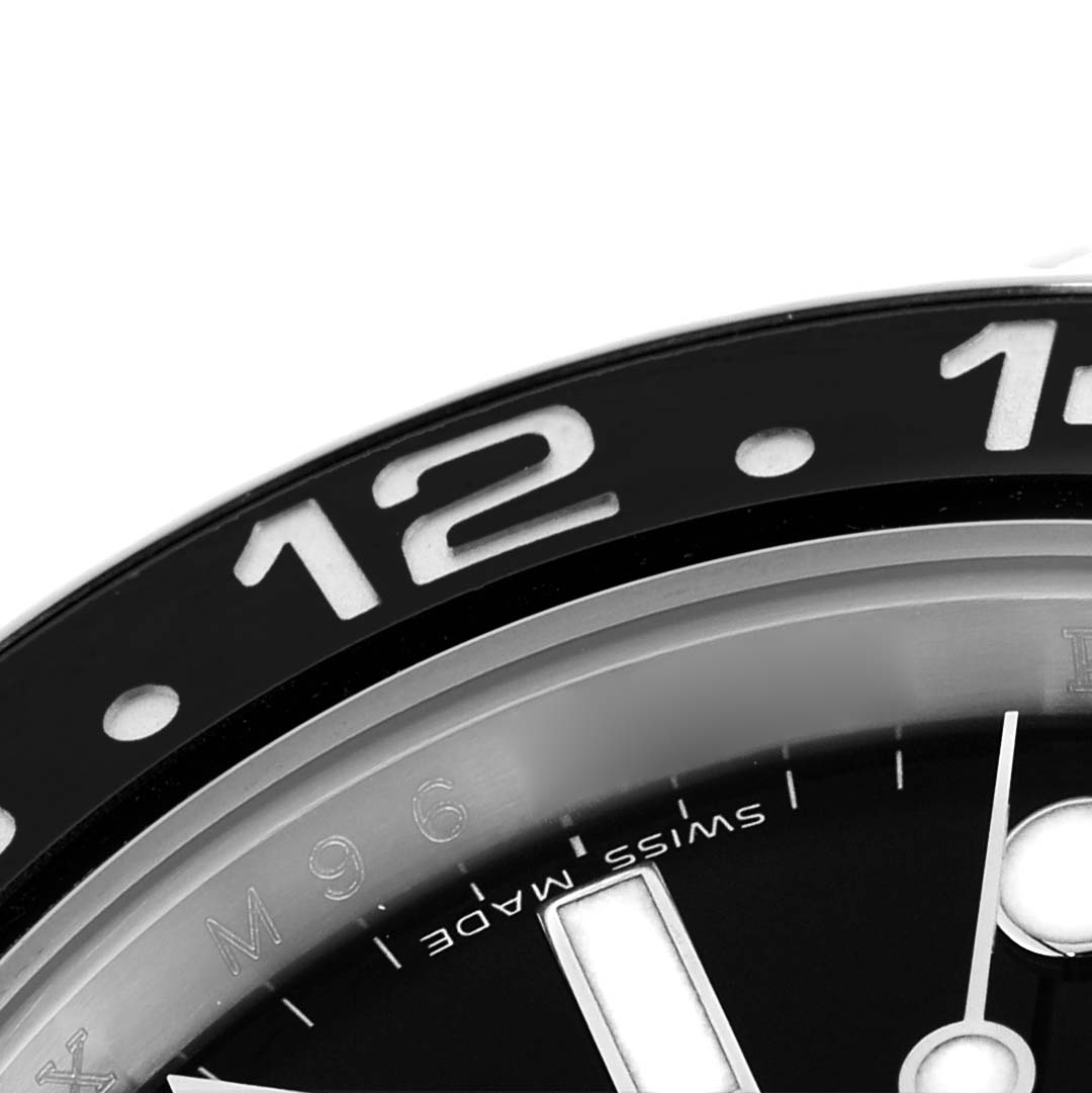 The image shows a close-up of the bezel and dial of a Rolex GMT-Master 116710 Men
s Stainless Steel Black Dial 116710 Men
s Stainless Steel Black Dial, focusing on the 12 o
clock marker and Swiss Made text.