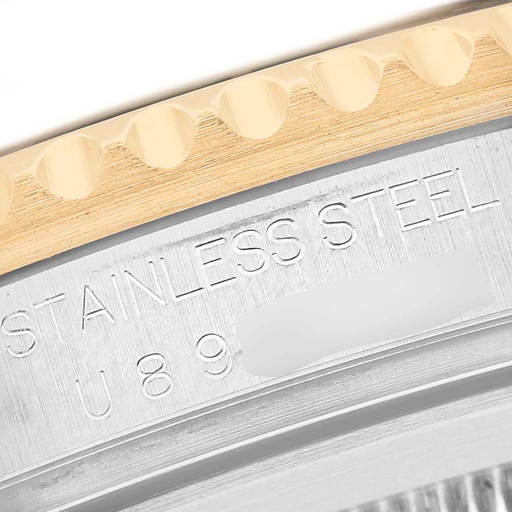 The image shows a close-up of the engraved stainless steel and ridged bezel on a Rolex GMT-Master 16713LN Men's Stainless Steel Black Dial watch.