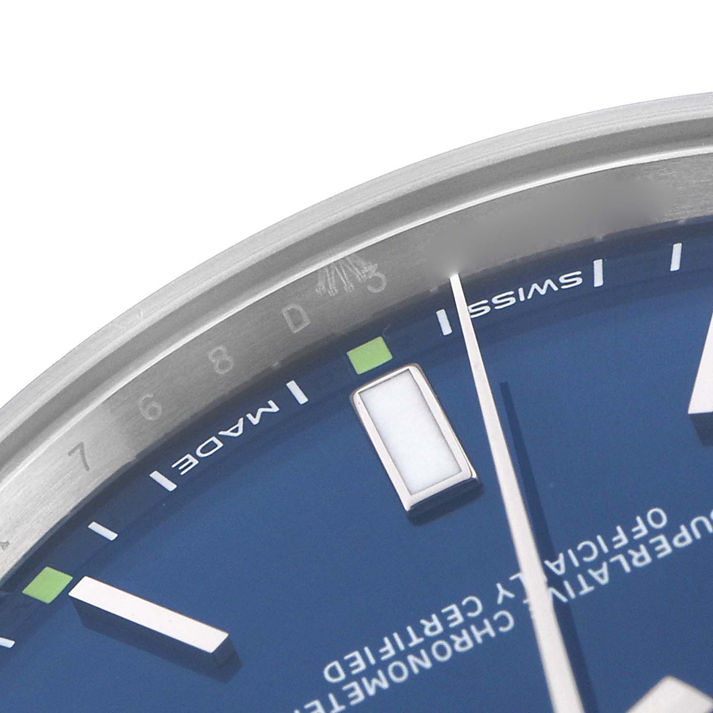 The close-up shows part of the Rolex Oyster Perpetual 114300 Men
s Stainless Steel Blue Dial 114300 Men
s Stainless Steel Blue Dial
s blue dial, markers, and hands at an oblique angle.