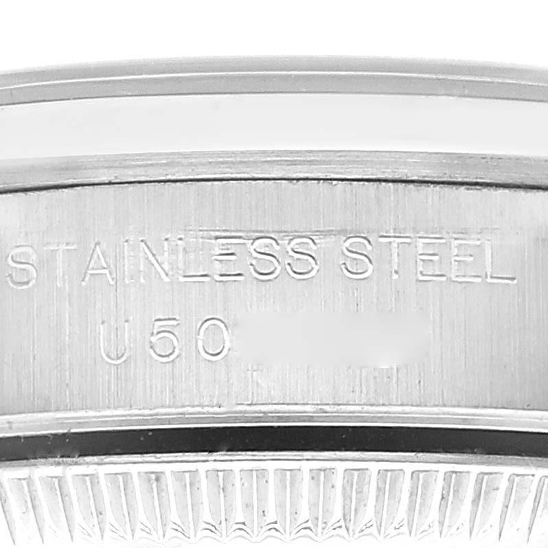 The image shows a close-up of the back casing of a Rolex Oyster Perpetual 67180 Women's Stainless Steel Black Dial 67180 Women's Stainless Steel Black Dial watch, detailing the stainless steel material and partial serial number.