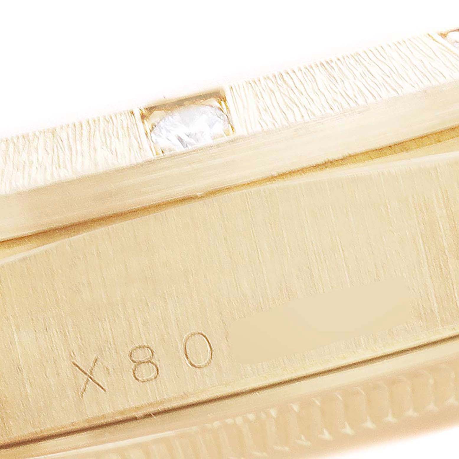 This image shows a close-up angle of the case side and bezel of a Rolex President 18308 Men's Yellow Gold Champagne Dial 18308 Men's Yellow Gold Champagne Dial model watch, highlighting a diamond and engraving.