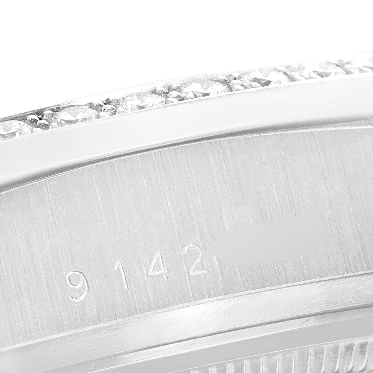 This close-up image shows the side view of the Rolex President 18049 Men
s White Gold Silver Dial 18049 Men
s White Gold Silver Dial model
s bezel and engraved serial number.