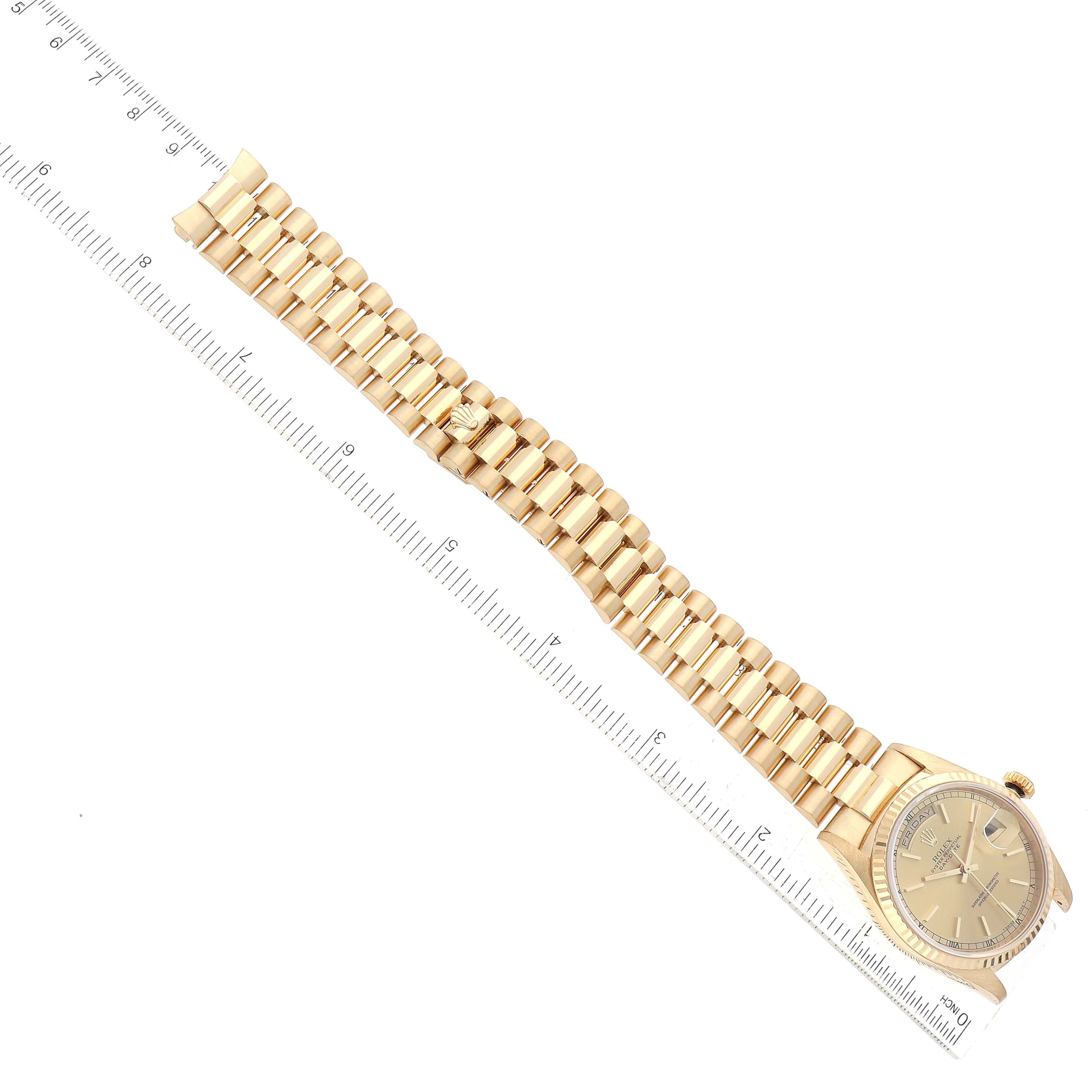The image shows a top view of the Rolex President 18238 Men's Yellow Gold Champagne Dial model, featuring its gold bracelet and watch face alongside a ruler for scale.