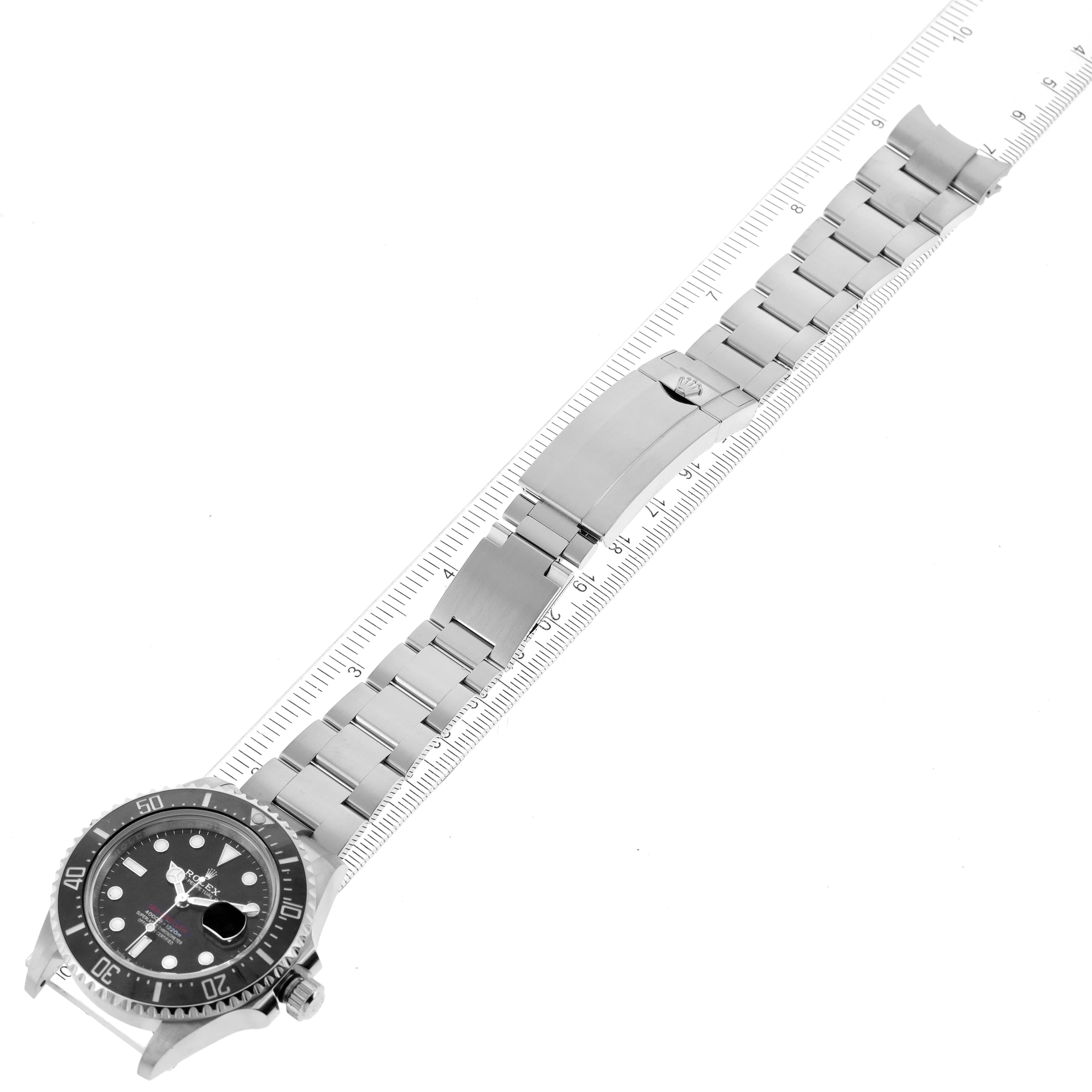 The Rolex Sea-Dweller 126600 Men
s Stainless Steel Black Dial 126600 Men
s Stainless Steel Black Dial watch is shown at an angle showcasing the face, bezel, bracelet, and clasp, along with a ruler for scale.