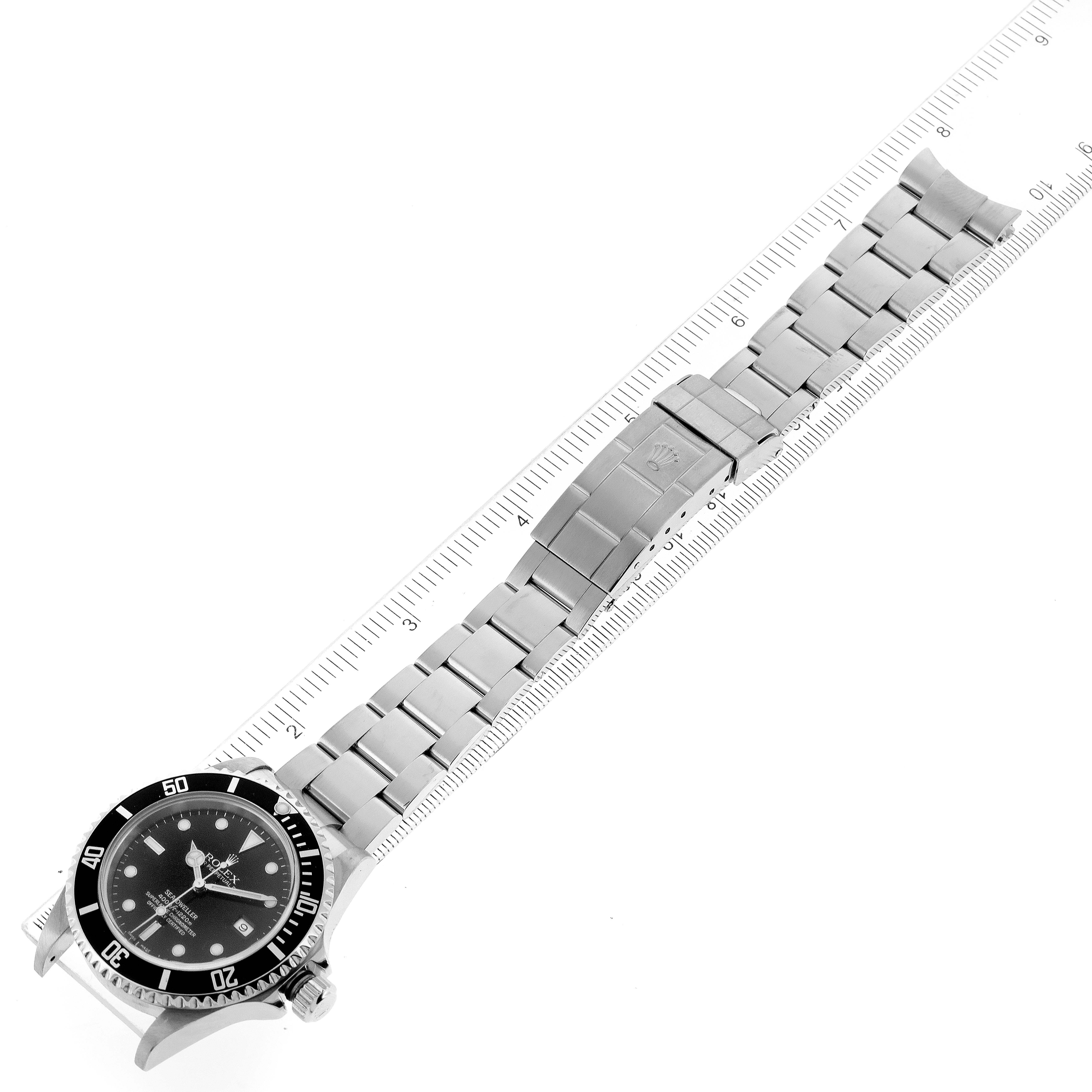 The image shows the Rolex Sea-Dweller 16600 Men
s Stainless Steel Black Dial 16600 Men
s Stainless Steel Black Dial watch laid flat with the bracelet and clasp along a ruler.