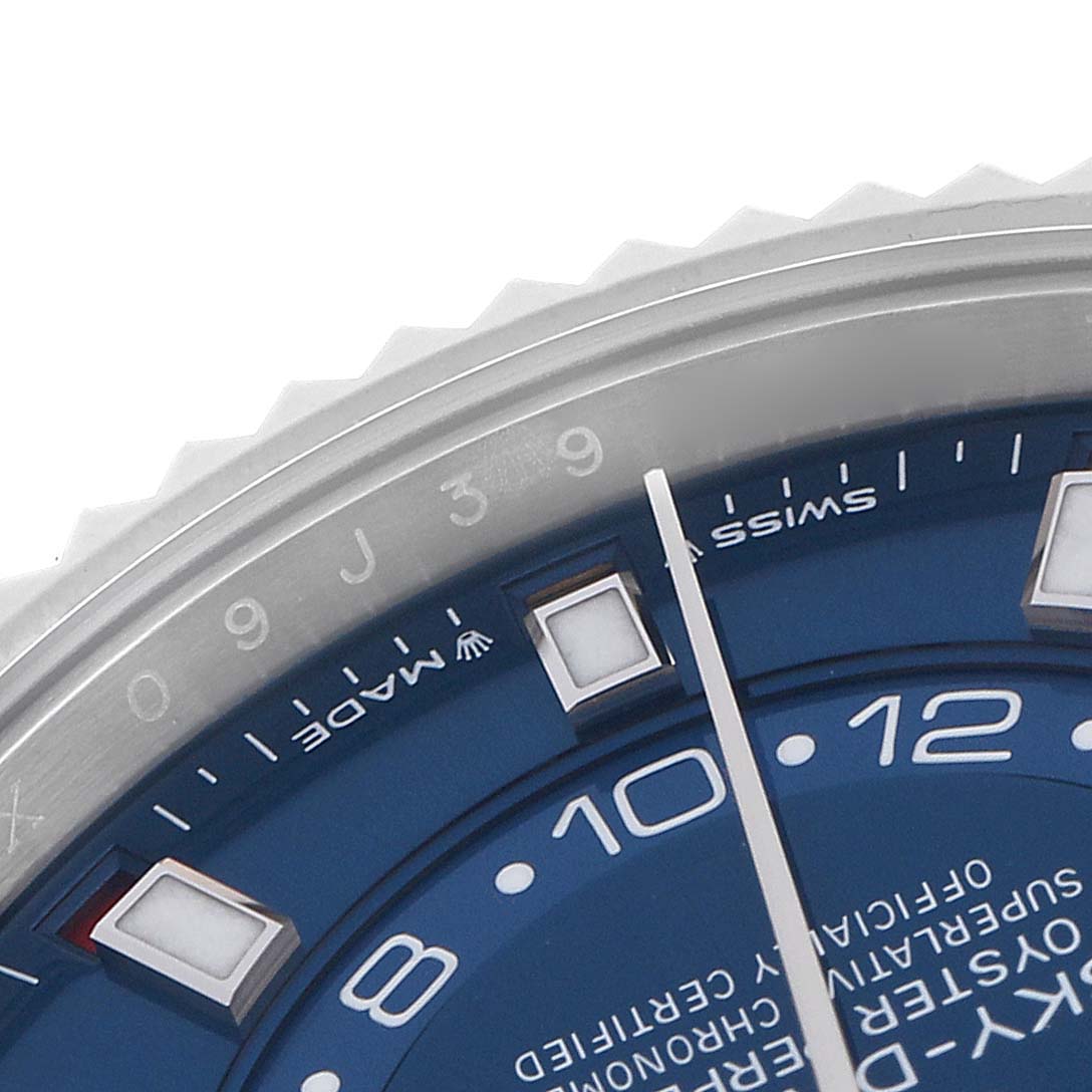 The image shows a close-up of the Rolex Sky-Dweller 336934 Men
s Stainless Steel Blue Dial 336934 Men
s Stainless Steel Blue Dial
s bezel, hour markers, and part of the dial and hand from an angle.