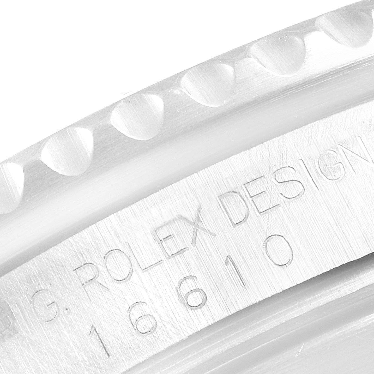 The image shows a close-up of the engraved serial number and part of the bezel of a Rolex Submariner 16610 Men
s Stainless Steel Black Dial 16610 Men
s Stainless Steel Black Dial watch.