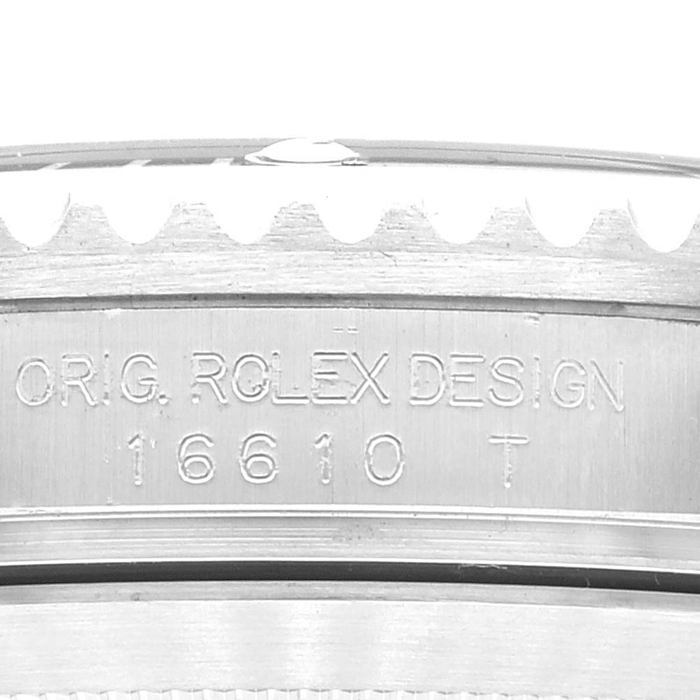 The image shows a close-up of the case side of a Rolex Submariner 16610 Men
s Stainless Steel Black Dial 16610 Men
s Stainless Steel Black Dial, displaying the model number "16610T" and "Orig. Rolex Design" engraving.