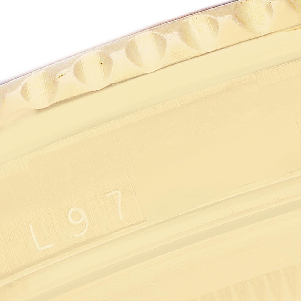 The image shows a close-up of the edge of the bezel and part of the case back of a Rolex Submariner 16618 Men's Yellow Gold Champagne Dial 16618 Men's Yellow Gold Champagne Dial.