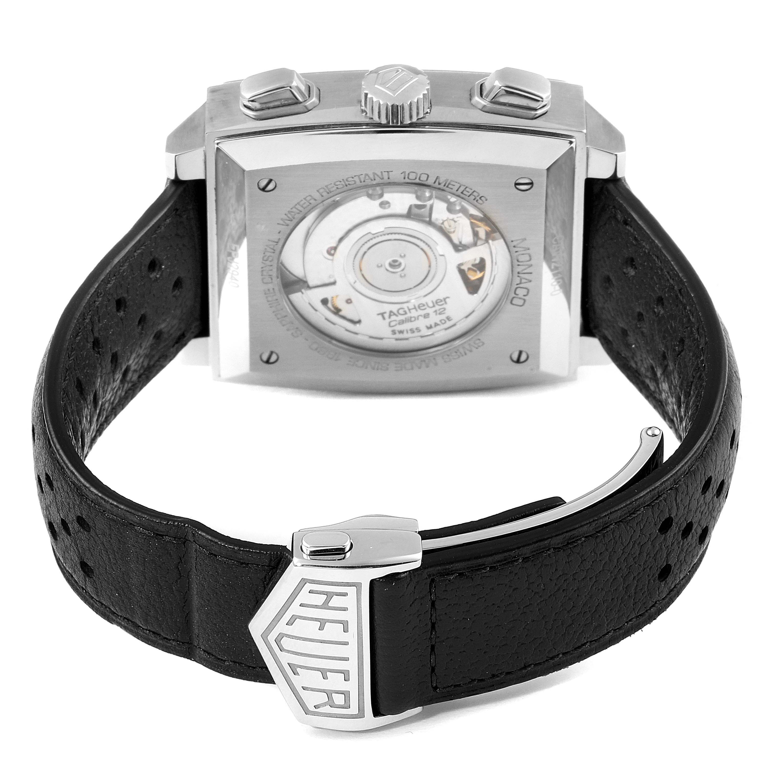 The image shows the back angle of a Tag Heuer Monaco CAW2110.FC6177 Men's Stainless Steel Black Dial CAW2110.FC6177 Men's Stainless Steel Black Dial watch, highlighting the movement mechanism and leather strap with a clasp.