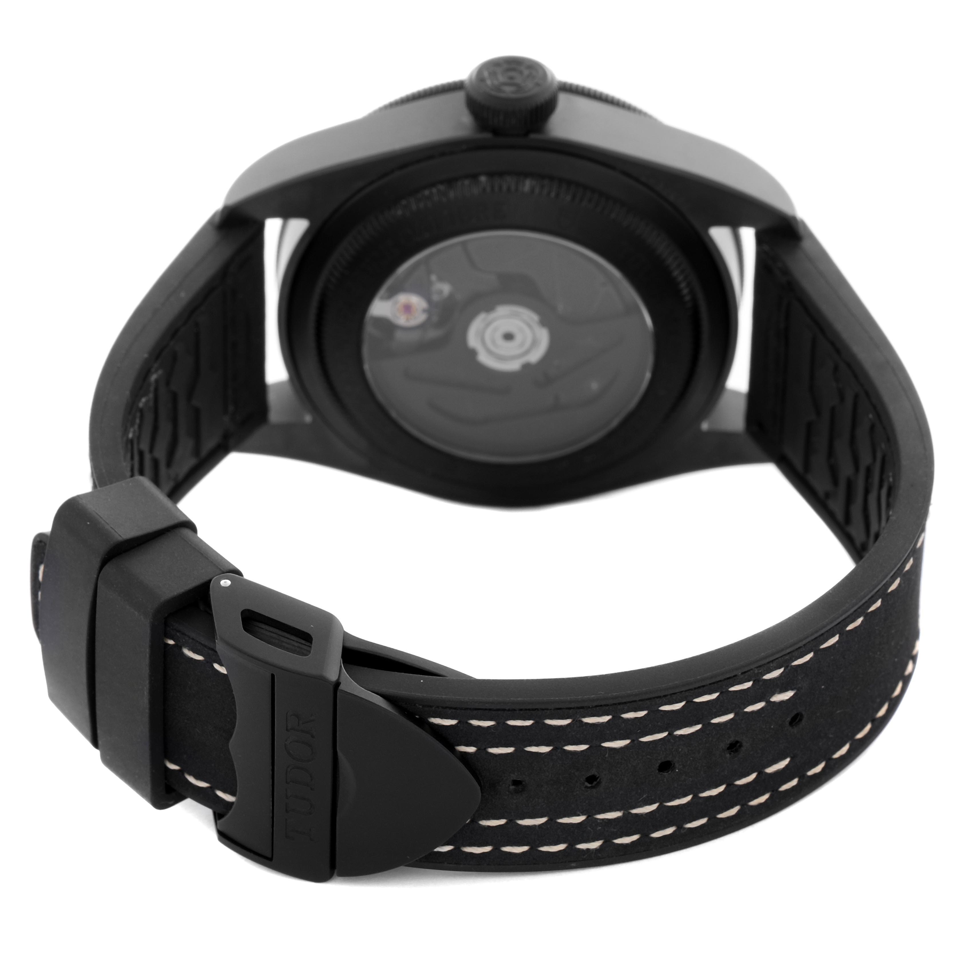 This image shows the back of the Tudor Heritage Black Bay 79210 Men
s Ceramic Black Dial 79210 Men
s Ceramic Black Dial watch, highlighting its case back and leather strap with stitching.