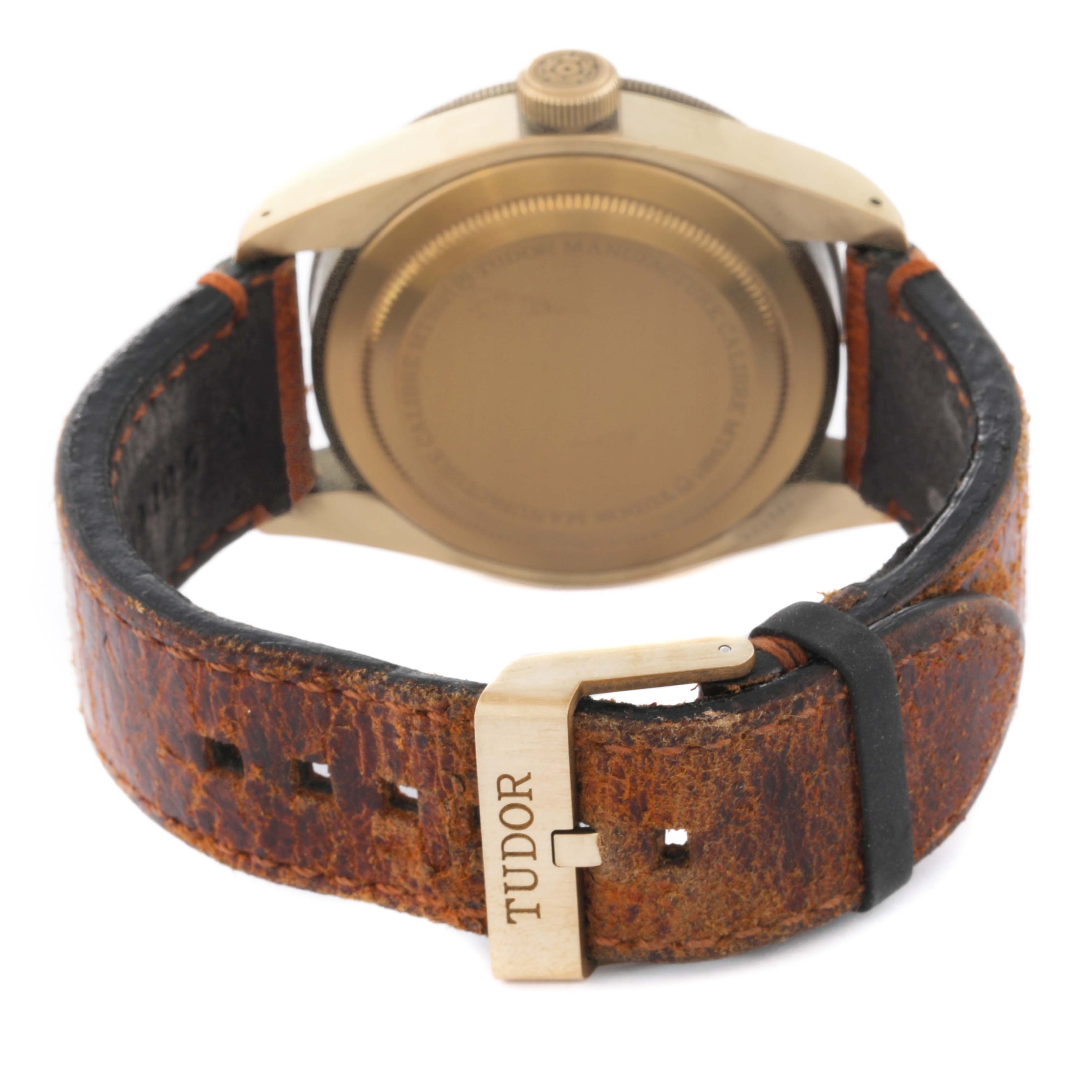 The image shows the back case and leather strap, including the buckle with the brand name "Tudor" inscribed, of the Tudor Heritage Black Bay 79250B Men's Bronze Brown Dial 79250B Men's Bronze Brown Dial watch.