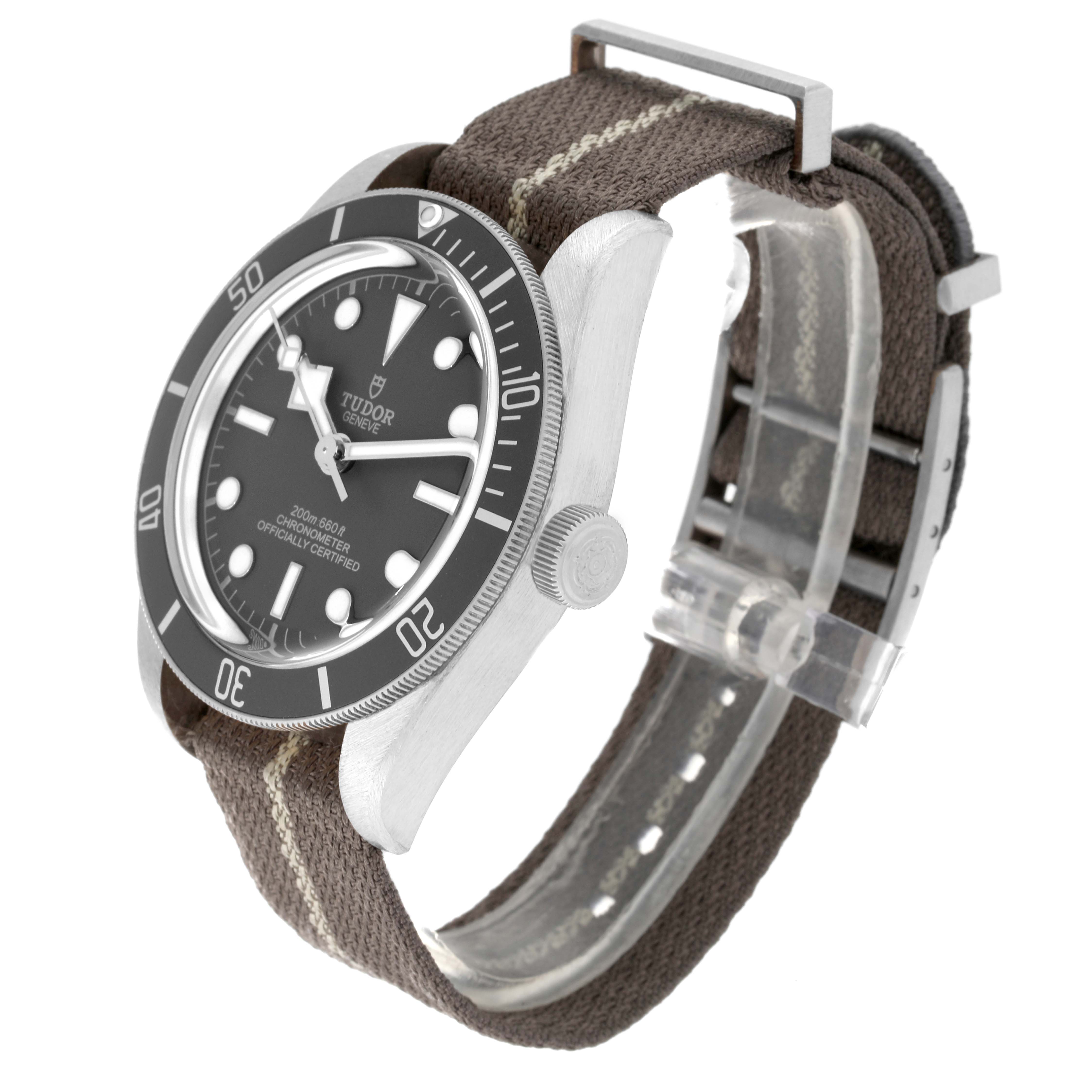 The image shows a side and front angle of the Tudor Heritage Black Bay 79010SG Men
s Stainless Steel Grey Dial 79010SG Men
s Stainless Steel Grey Dial watch, highlighting its bezel, dial, and fabric strap.
