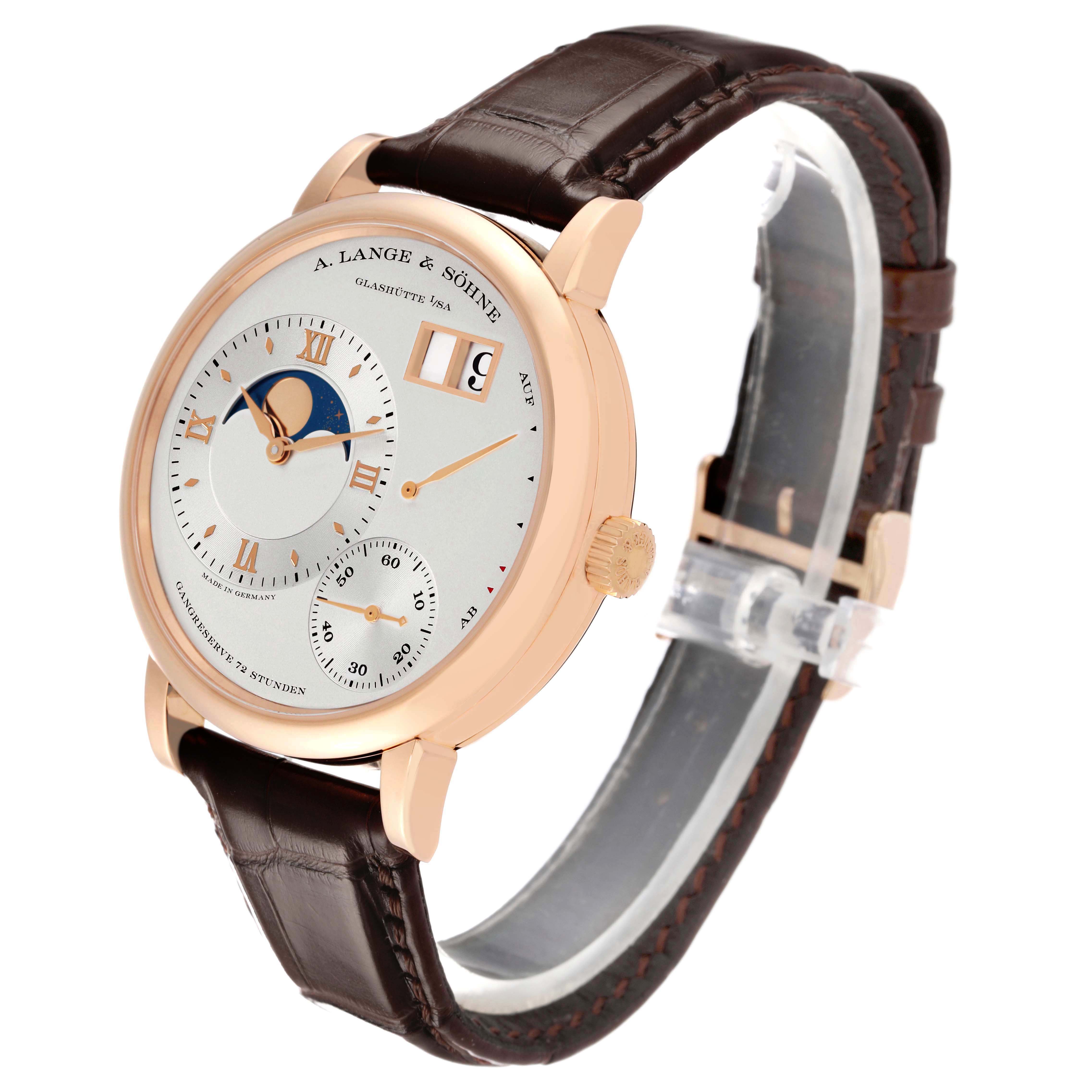 The A. Lange & Sohne Lange 1 139.032 Men's Rose Gold Silver Dial watch is shown at a three-quarter angle, highlighting its face, crown, and brown leather strap.