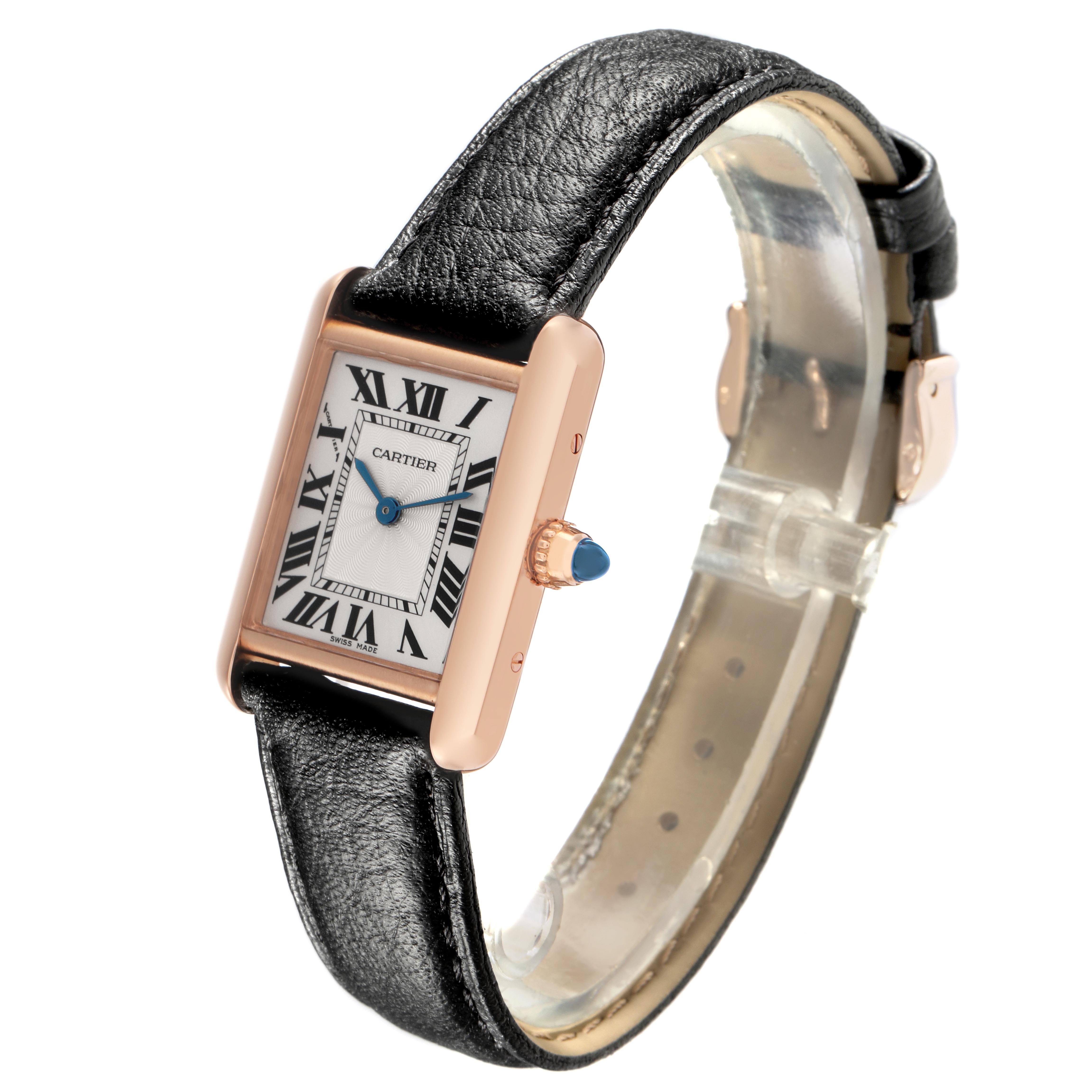 The Cartier Tank Louis WGTA0010 Women
s Rose Gold Silver Dial WGTA0010 Women
s Rose Gold Silver Dial watch is shown at a slight angle, displaying its face, leather strap, and crown with a blue gemstone.
