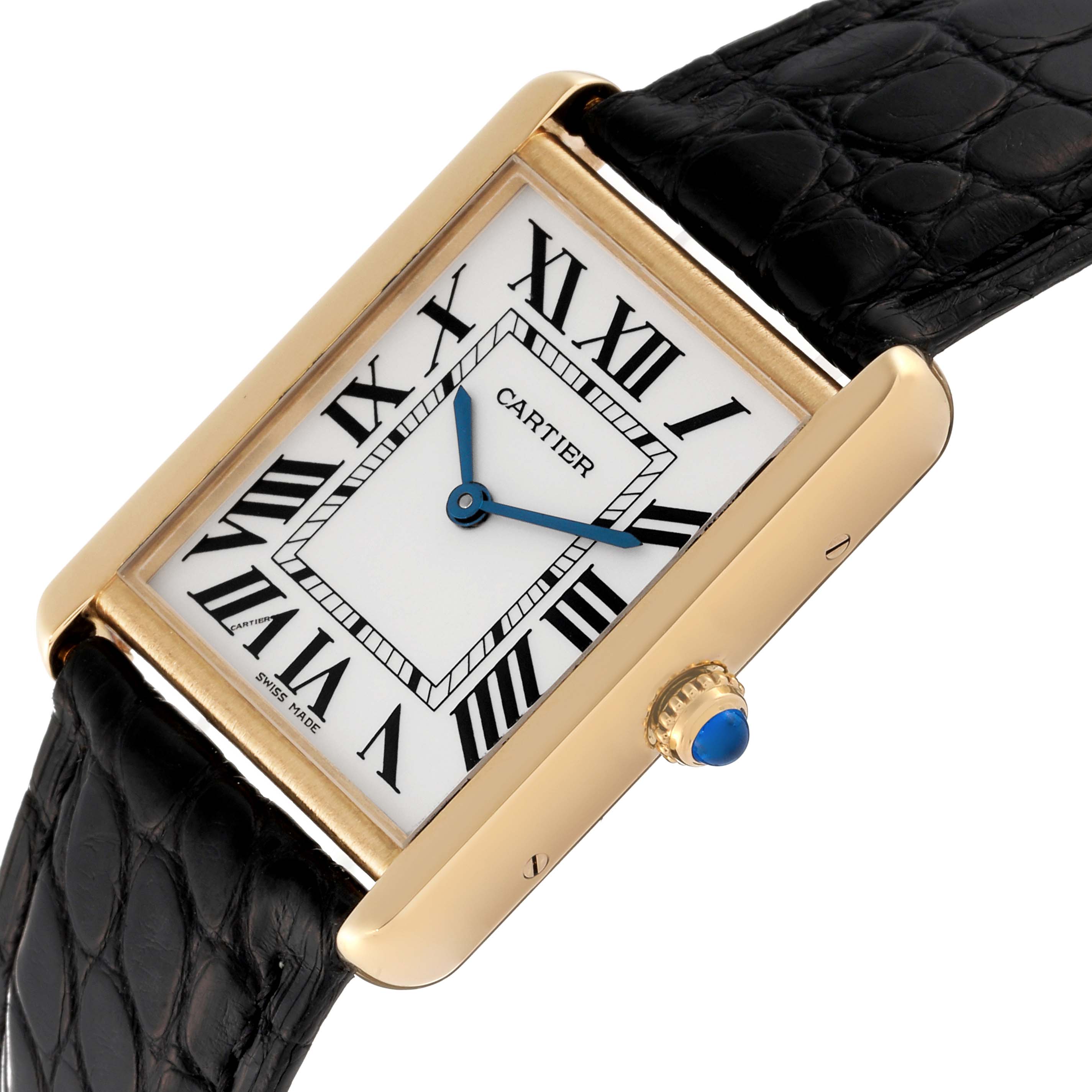 The Tank Solo by Cartier is shown at an angle, featuring its rectangular face, Roman numerals, blue hands, and black leather strap.