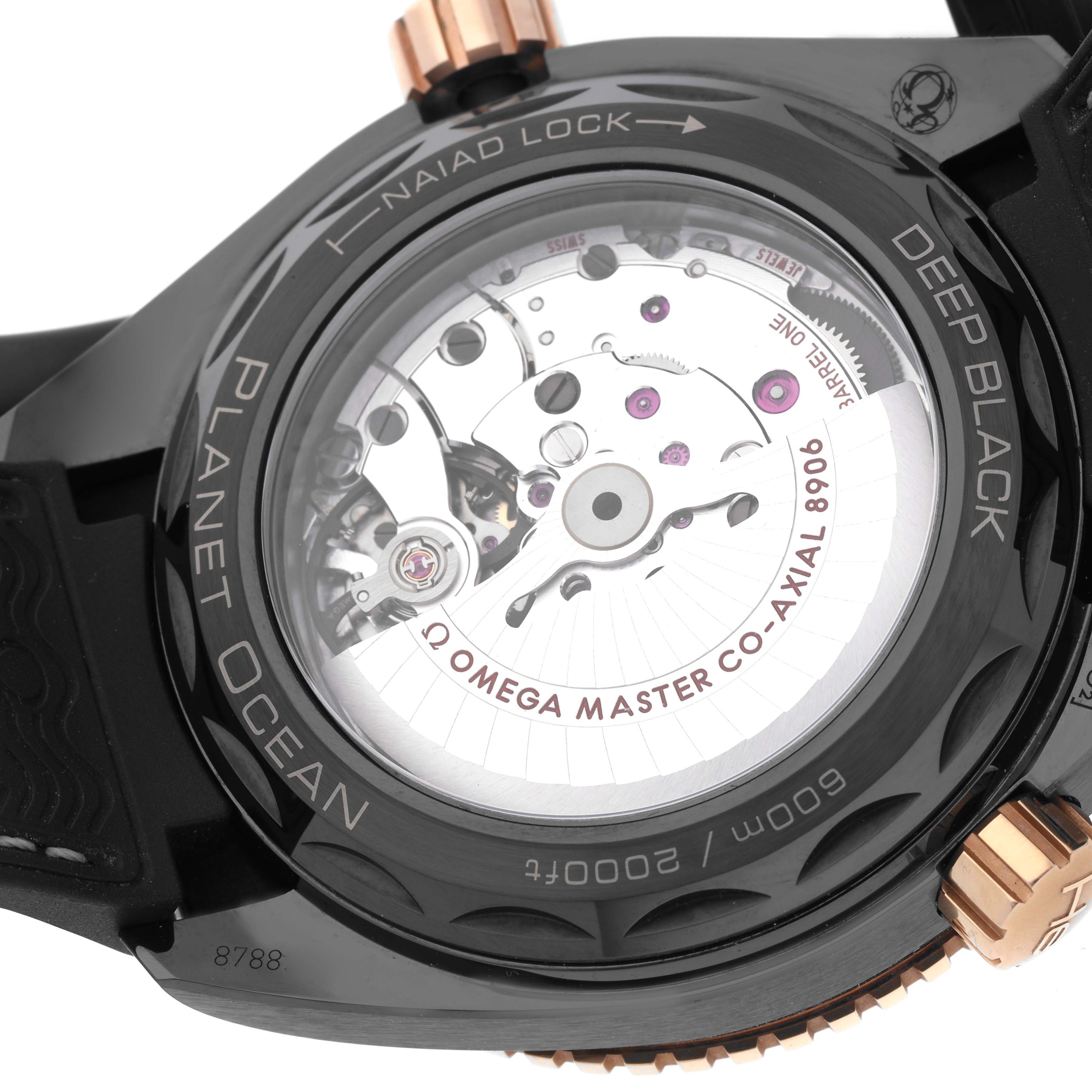 This image shows the back angle of an Omega Planet Ocean 215.63.46.22.01.001 Men's Ceramic Black Dial 215.63.46.22.01.001 Men's Ceramic Black Dial watch, displaying its intricate movement and "Master Co-Axial 8906" mechanism.