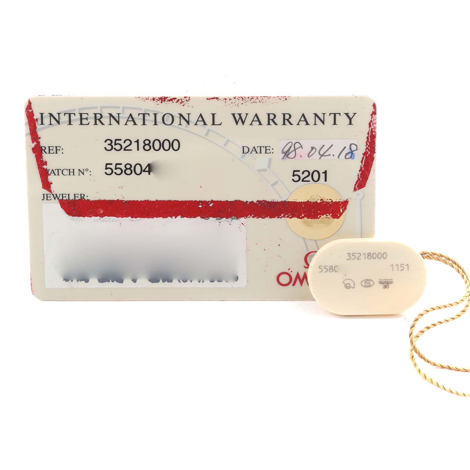 The image shows an Omega Speedmaster 3521.80.00 Men
s Stainless Steel Blue Dial 3521.80.00 Men
s Stainless Steel Blue Dial International Warranty card and a tag, both viewed from the front.