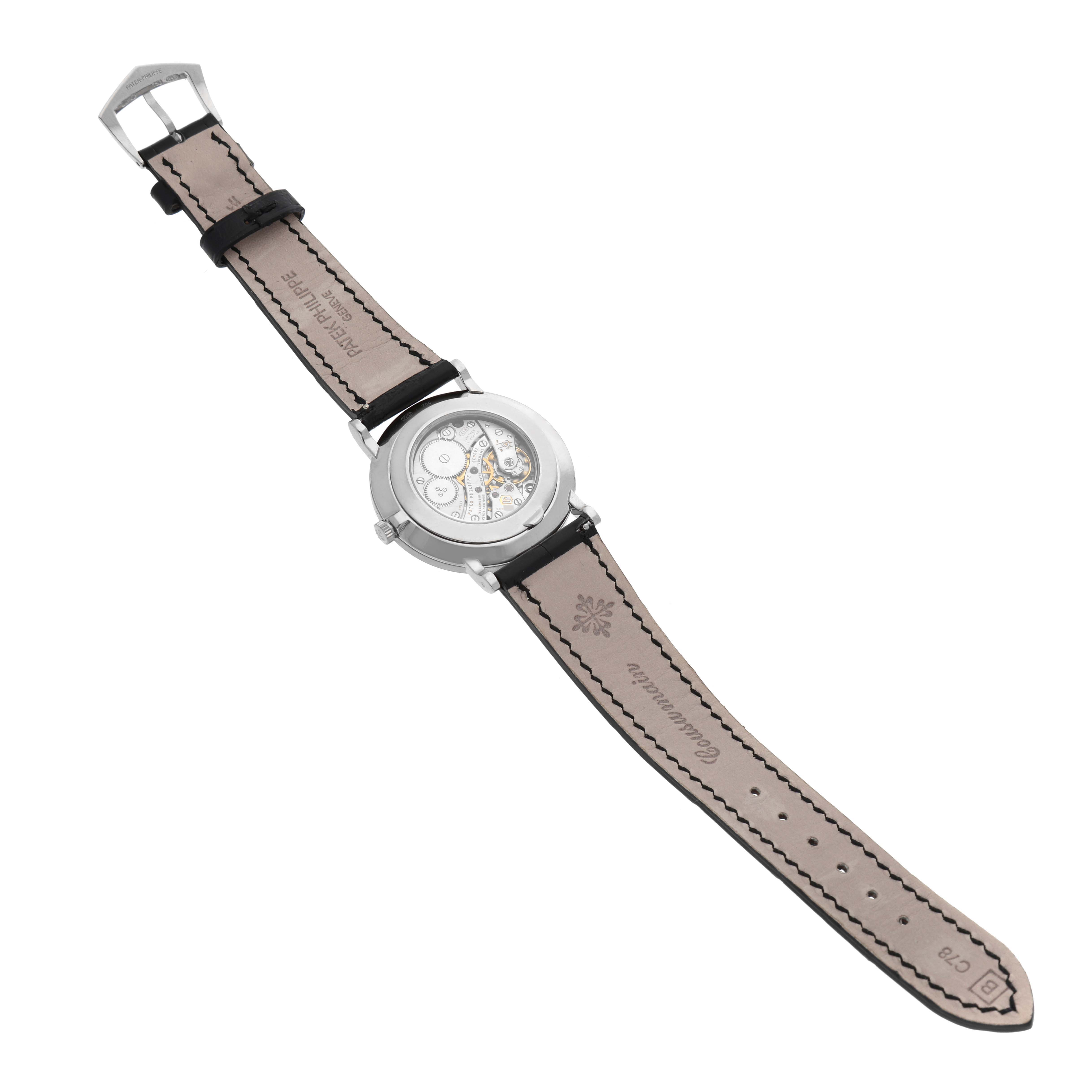 The image shows the back view of a Patek Philippe Calatrava 5116G Men
s White Gold White Dial 5116G Men
s White Gold White Dial watch, displaying the leather strap and the watch
s inner mechanism.