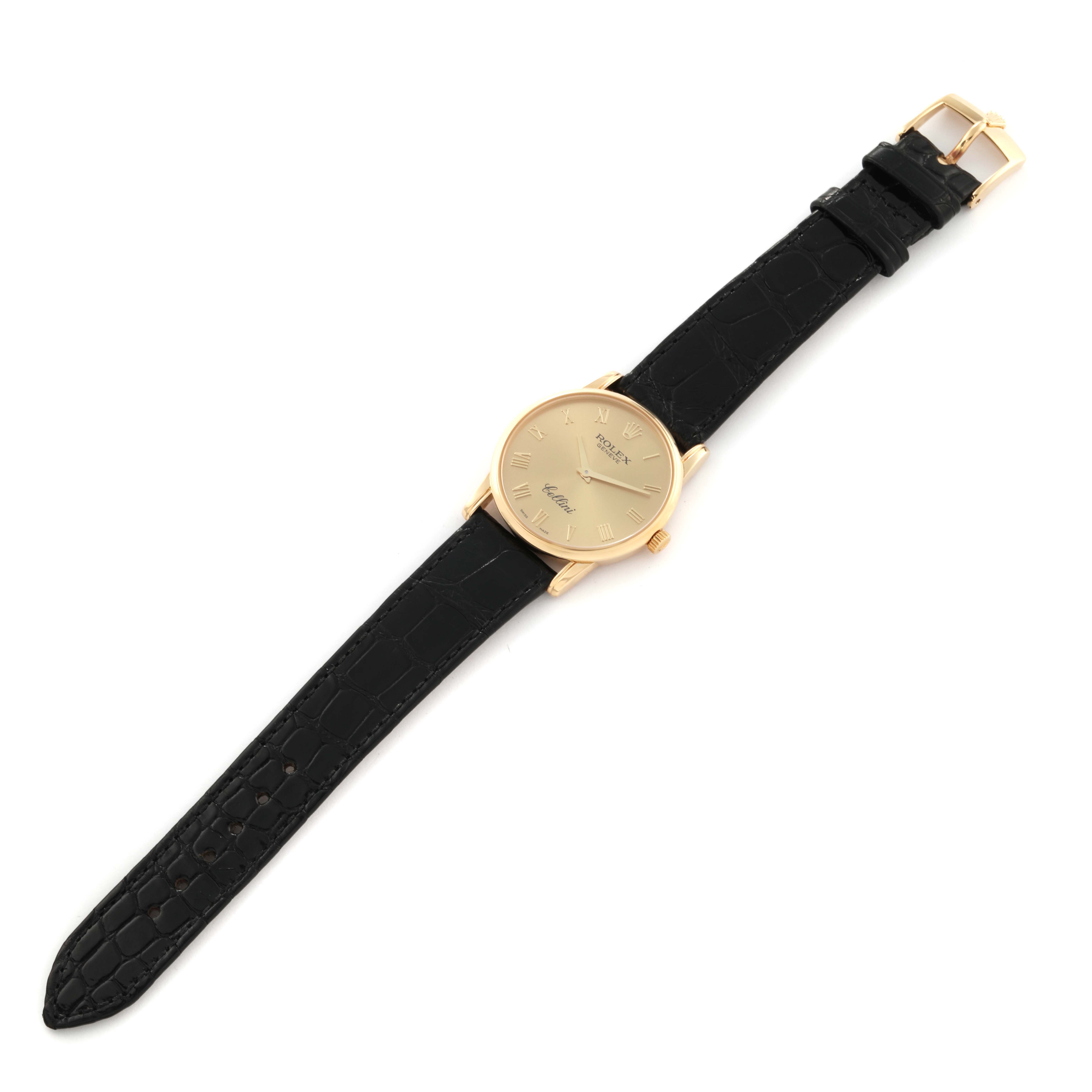 This image shows a Rolex Cellini 5116 Men's Yellow Gold Champagne Dial 5116 Men's Yellow Gold Champagne Dial watch from a top-down angle, displaying its gold case, black leather strap, and face with Roman numerals.