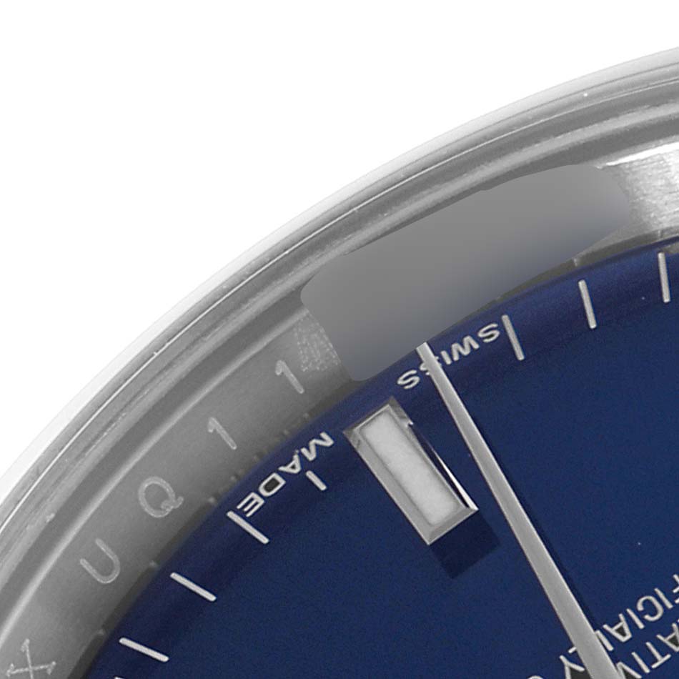 The image shows a close-up of the Rolex Date 115200 Men's Stainless Steel Blue Dial 115200 Men's Stainless Steel Blue Dial model watch, focusing on the edge of the dial and part of the bezel.