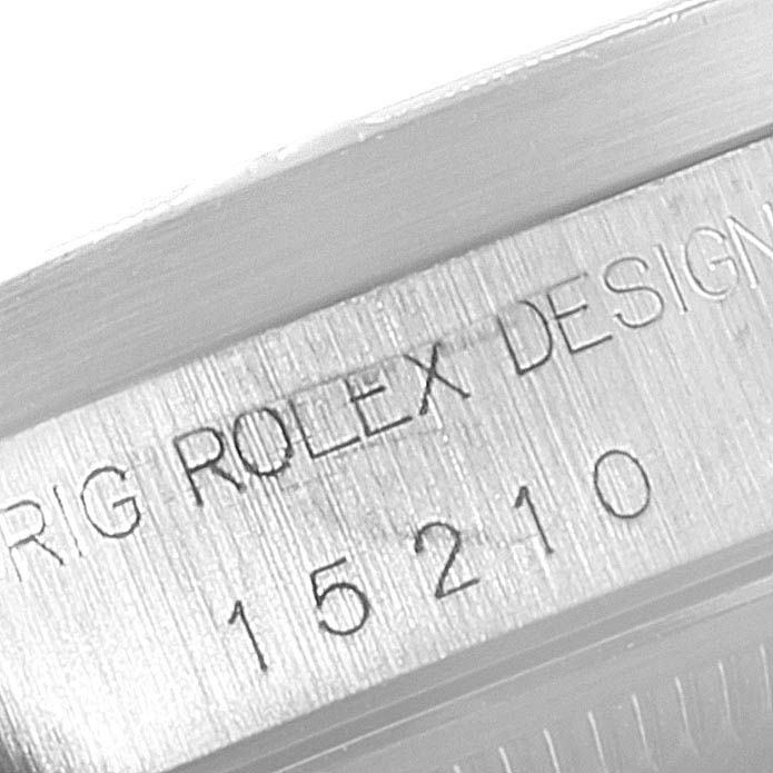 The image shows a close-up view of the serial number and "Rolex Design" engraving on the case side of a Rolex Date 15210 Men's Stainless Steel White Dial 15210 Men's Stainless Steel White Dial model watch.