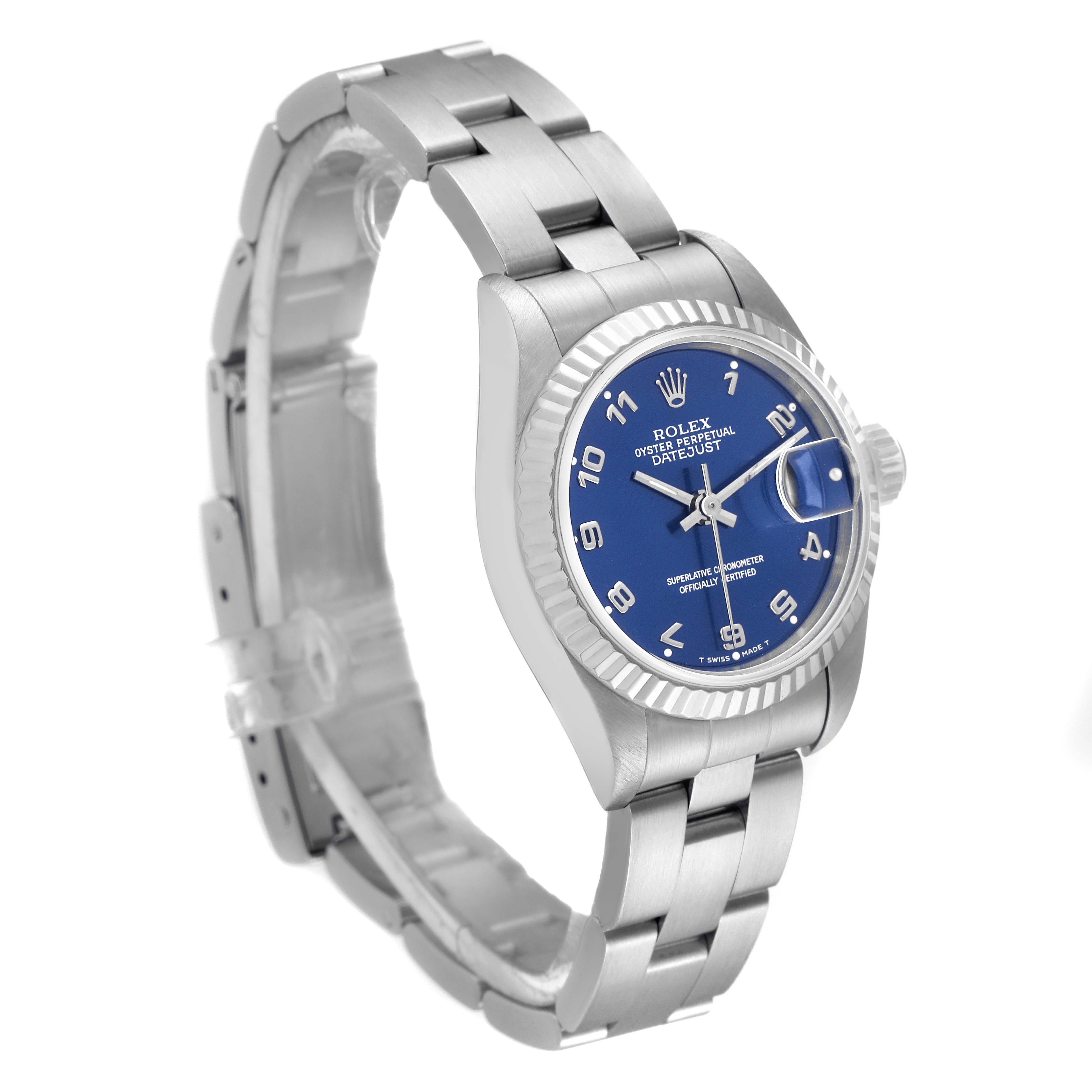 The image shows a Rolex Datejust 69174 Women
s Stainless Steel Blue Dial 69174 Women
s Stainless Steel Blue Dial watch at a three-quarter angle, highlighting the blue dial, fluted bezel, and Oyster bracelet.