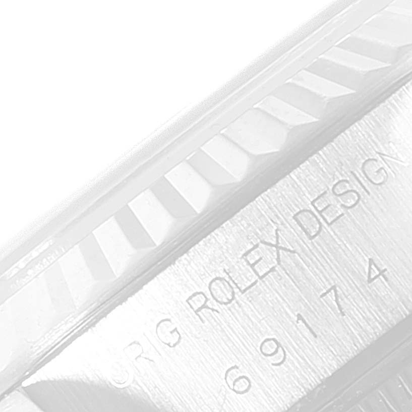 The image shows a close-up of the side of a Rolex Datejust 69174 Women
s Stainless Steel Blue Dial 69174 Women
s Stainless Steel Blue Dial, highlighting the fluted bezel and part of the engraved serial number.